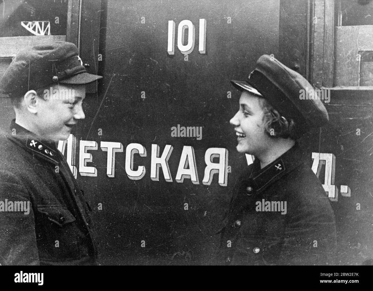 Il maestro della stazione Tamara Philipopova parla con Serezha Prokhorov uno dei dirigenti della ferrovia dei bambini. L'unica ferrovia interamente operata dai bambini è in servizio nell'Unione Sovietica a soli 25 miglia da Mosca. I bambini svolgono tutti i compiti sulla ferrovia, il sistema in miniatura serve uno scopo utile per fare conoscere ai giovani la tecnica ferroviaria. 25 luglio 1937 Foto Stock