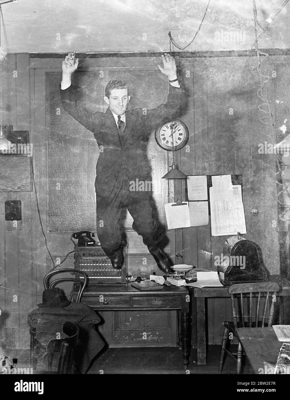 Nessun testo - uomo che salta da una scrivania di ufficio negli anni '30 Foto Stock