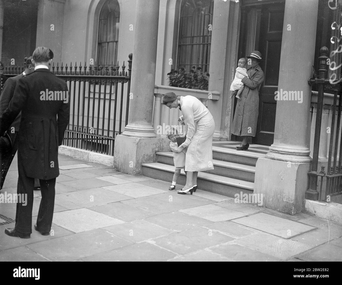 La duchessa di Kent che assiste il principe Edoardo lungo i passi dopo la sua caduta come infermiera segue con la principessa Alexandra. Cadde lasciando la sua casa in Piazza Belgrave. Per trascorrere una vacanza a Bloody Point House, vicino a Sandwich, Kent. 26 luglio 1937 Foto Stock