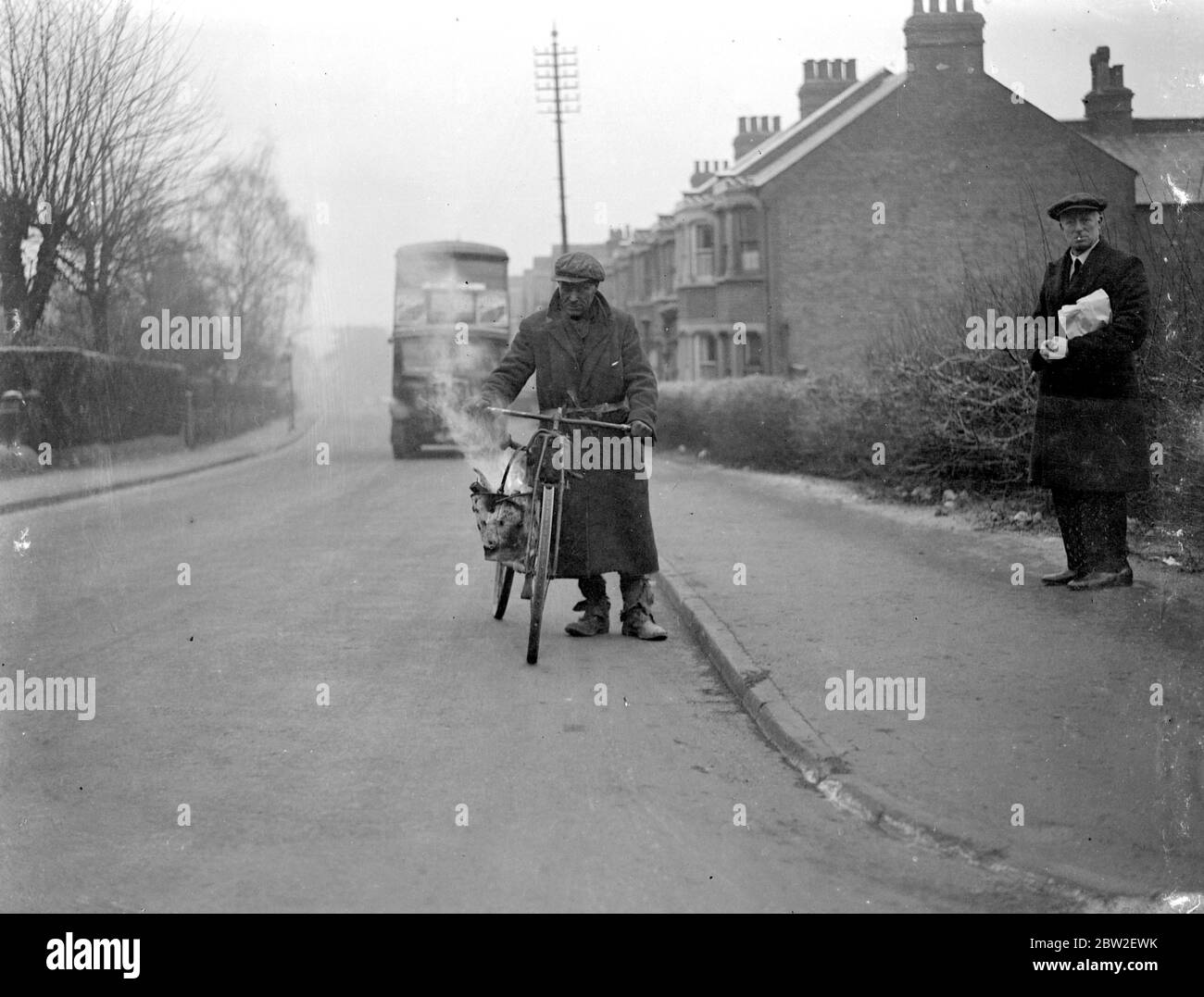 Tramp su una bicicletta, un autobus a due piani in background. (Comfort?) 1934 Foto Stock