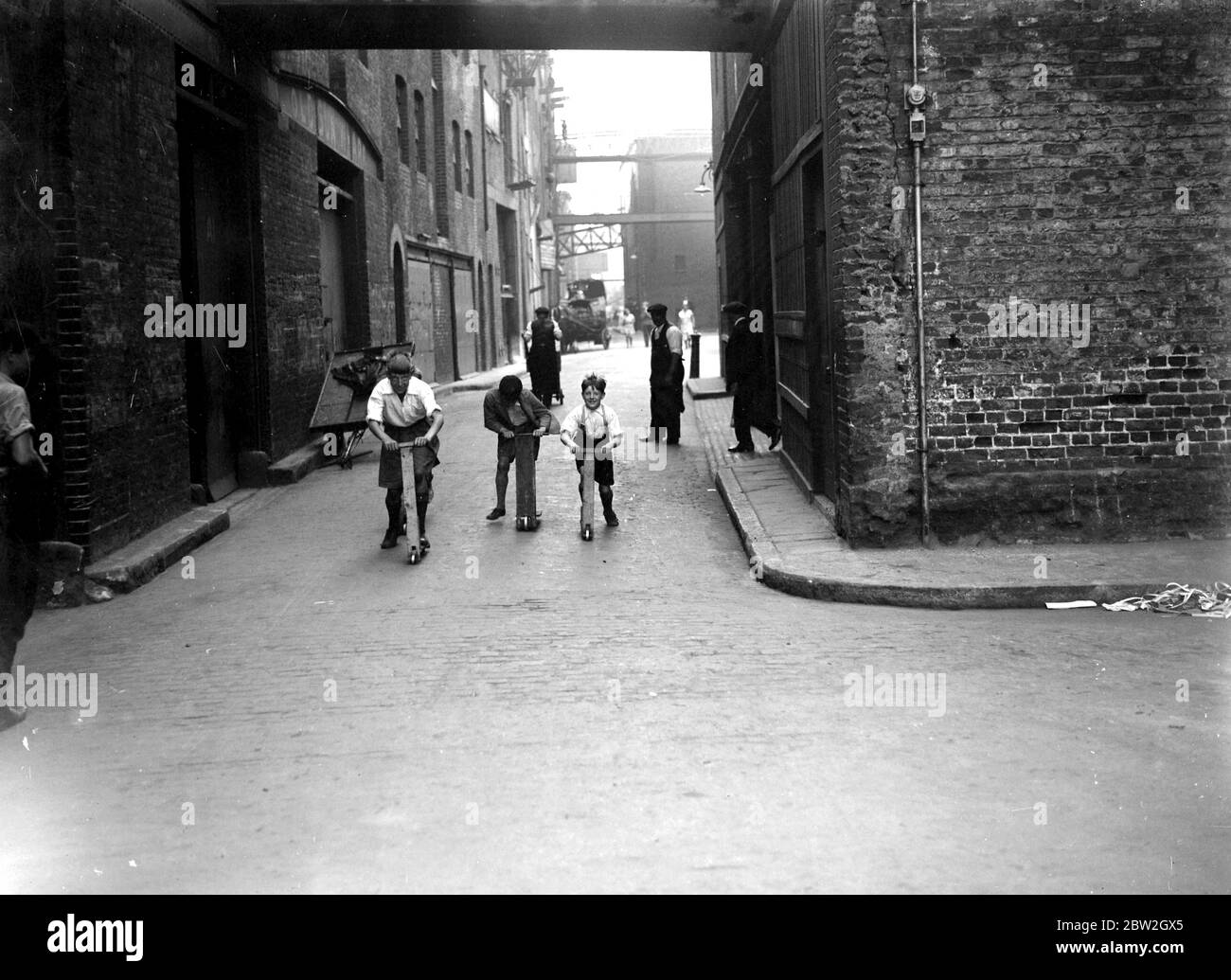 Le banchine all'estremità orientale di Londra, . Ragazzi che giocano sugli scooter. Foto Stock