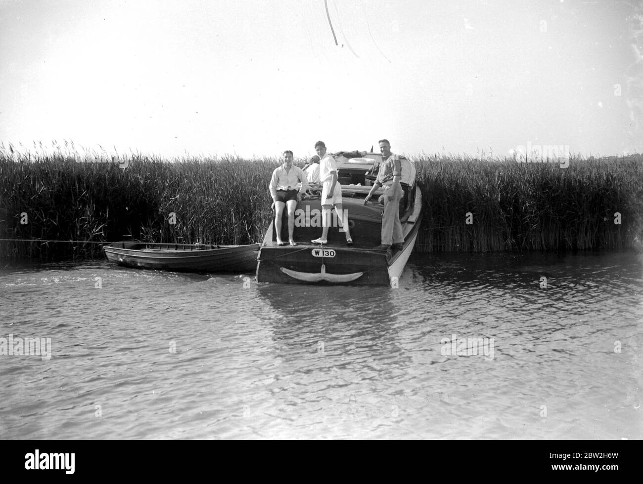Tre uomini in una barca sul Broads, Norfolk. Foto Stock