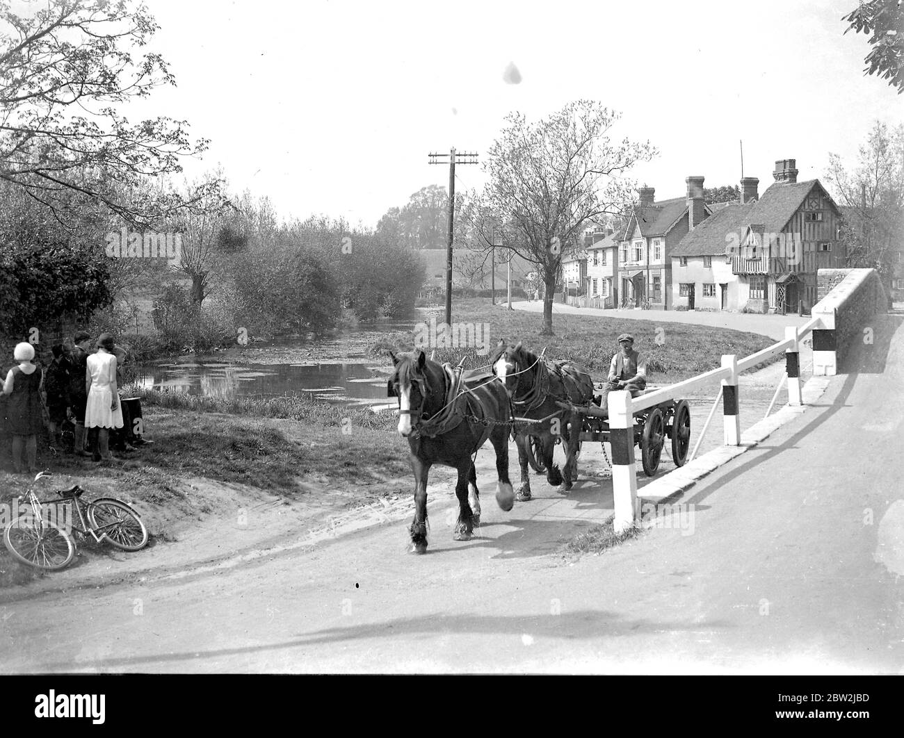 Un uomo guida il suo carro trainato da cavalli shire attraverso Eynsford, Kent. 1934 Foto Stock