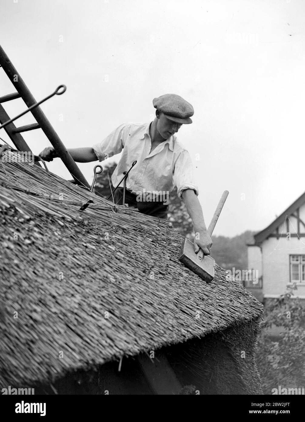 L'artigianato del thatching - al lavoro sul thatching il pittoresco Old Cottage all'angolo di Roehampton Lane, Barnes . 31 luglio 1928 Foto Stock