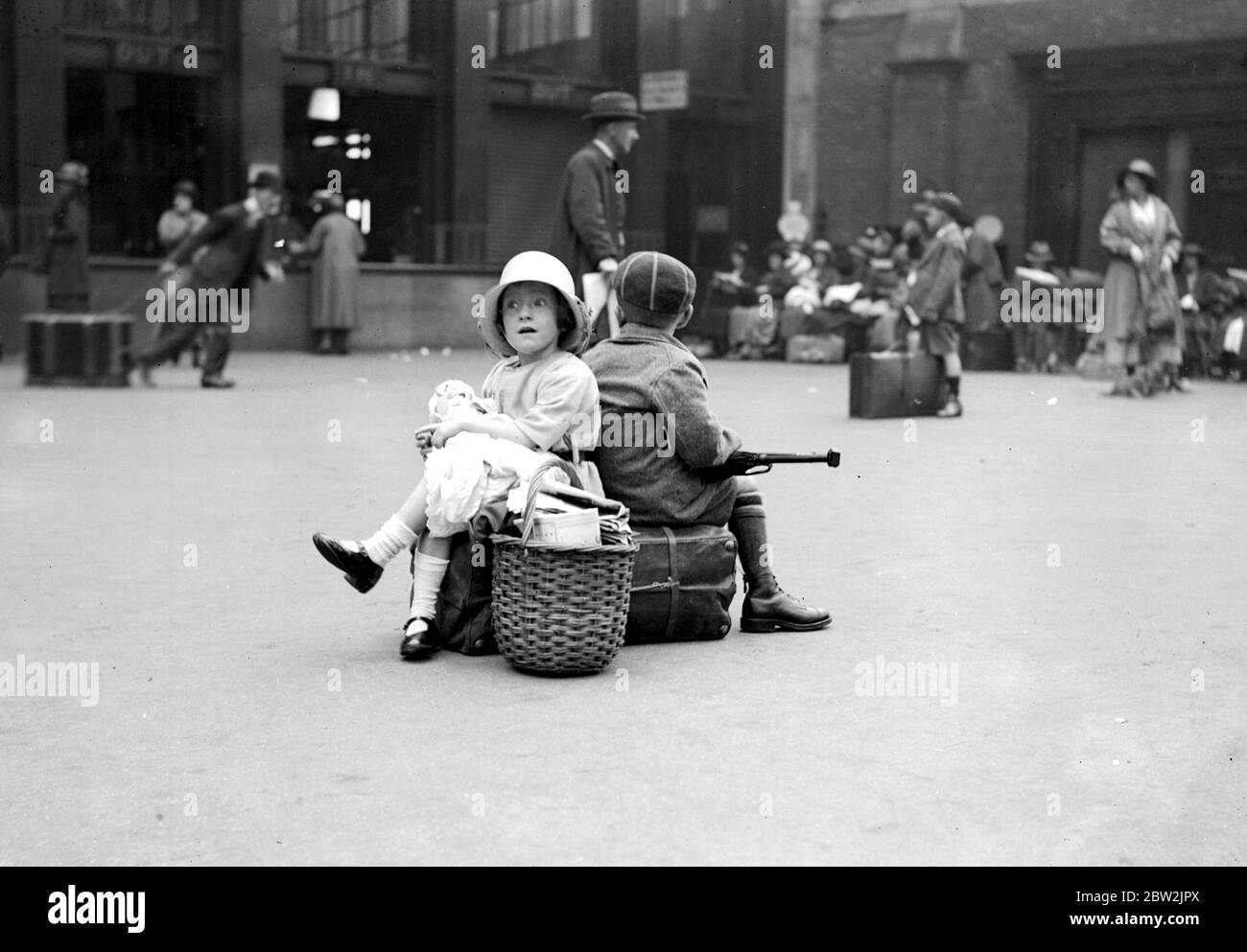 August Bank Holiday Scenes-Waterloo Station - aspettando mentre papà riceve i biglietti. 5 luglio 1922 Foto Stock