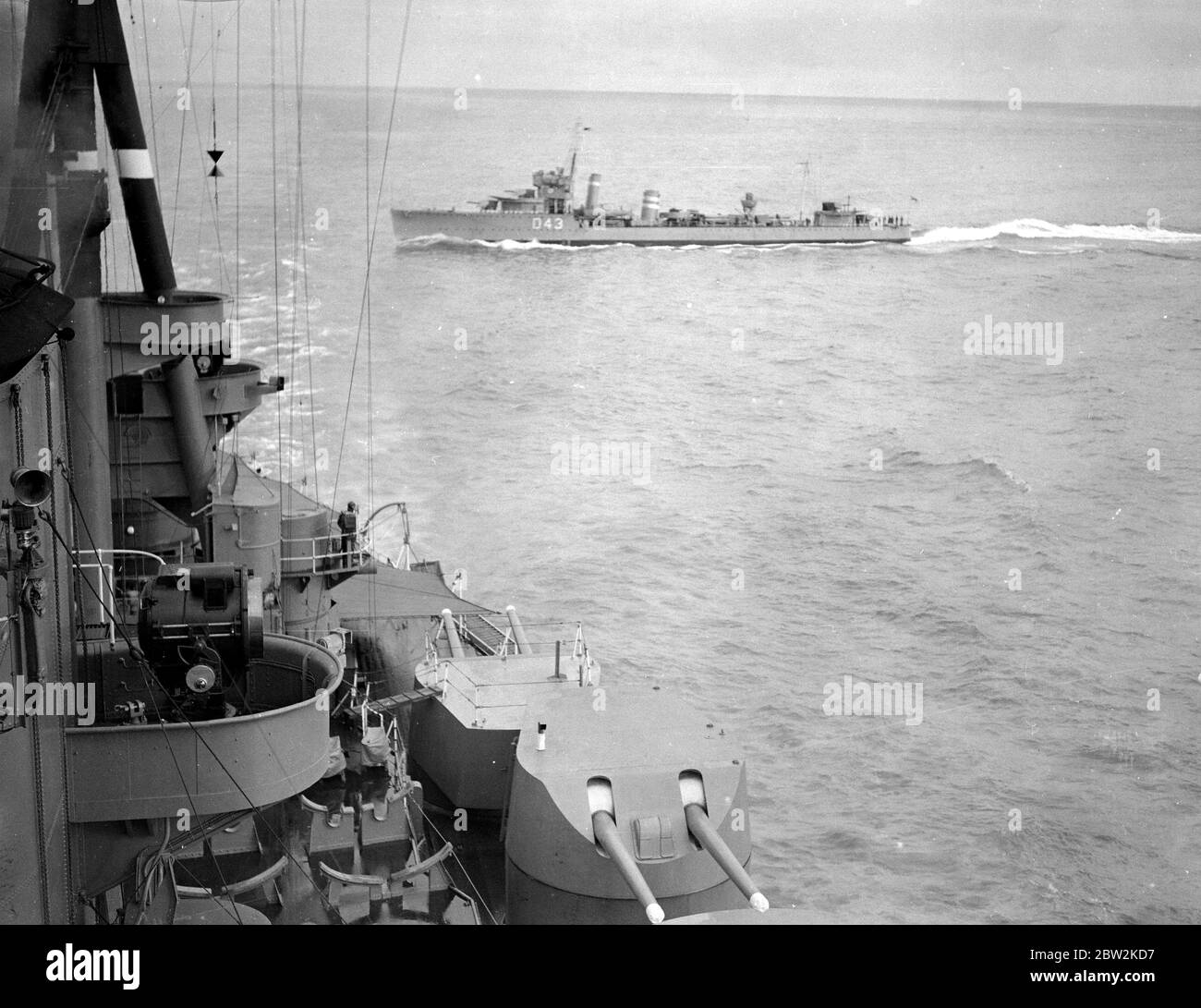 Visita dei Dominion Premiers alla flotta di Portland. Il cacciatorpediniere HMS Wessex (D43) taglia attraverso le fiocchi di H.M.S Nelson per attaccare il sottomarino che l'aveva silurata. 1930 Foto Stock