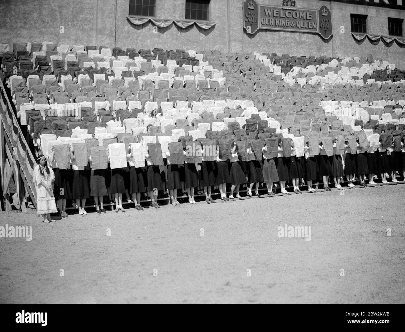 Il giro reale del Canada e degli Stati Uniti da re George VI e dalla regina Elizabeth, 1939 il re e la regina hanno accolto con una bandiera di Union Jack a Saskatoon, Saskatchewan dagli allievi indiani della ragazza e Ninaki , una donna principale degli indiani Blackfeet fra le folle. Foto Stock