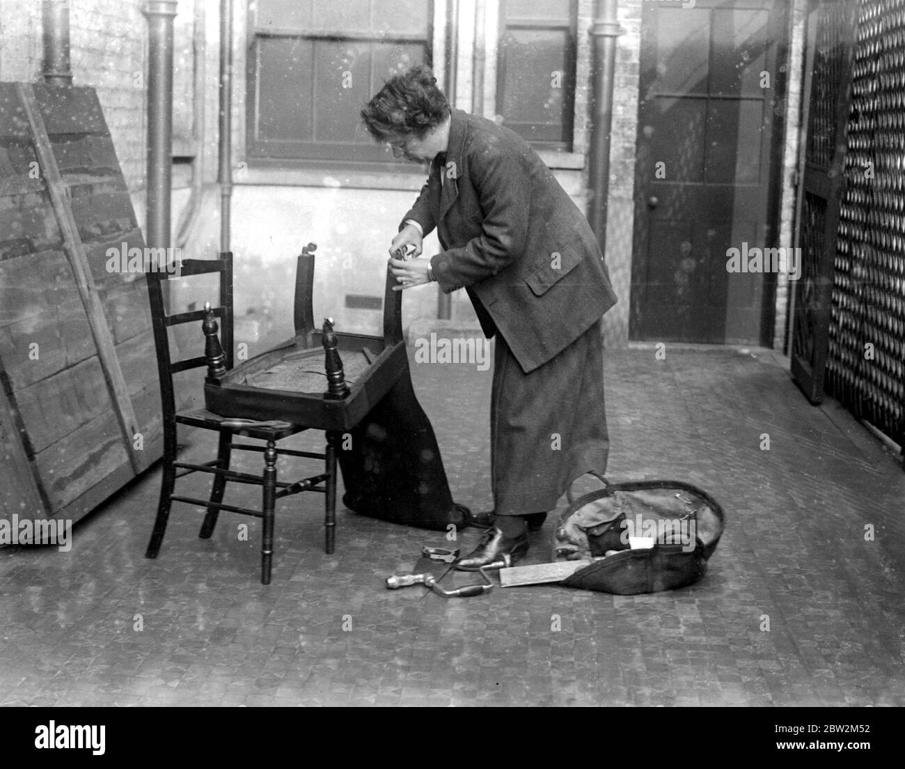 Sig.ra A. Browwn di Palmer St, Westminster. Le prime donne a praticare la carpenteria effettuano tutti i tipi di lavori di carpenteria, in particolare nei rami di alterazione degli arredi per la casa, di riparazione dei mobili, ecc. Sig.ra Brown riparando una sedia. 1914-1918 Foto Stock