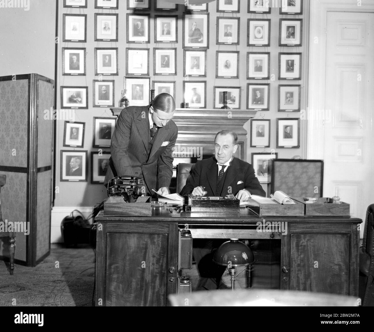 Alla sua scrivania presso l'ufficio domestico. Sir John Anderson, nominato di recente Lord Privy Seal con il suo segretario, il sig. Norman Brook. 7 novembre 1938 Anderson, John, Sir (Visconte Waverly) politico britannico; governatore del Bengala 1932-1937; segretario di casa britannico 1939-1940; cancelliere britannico dello scacchiere 1943-1945  1882-1958 Foto Stock