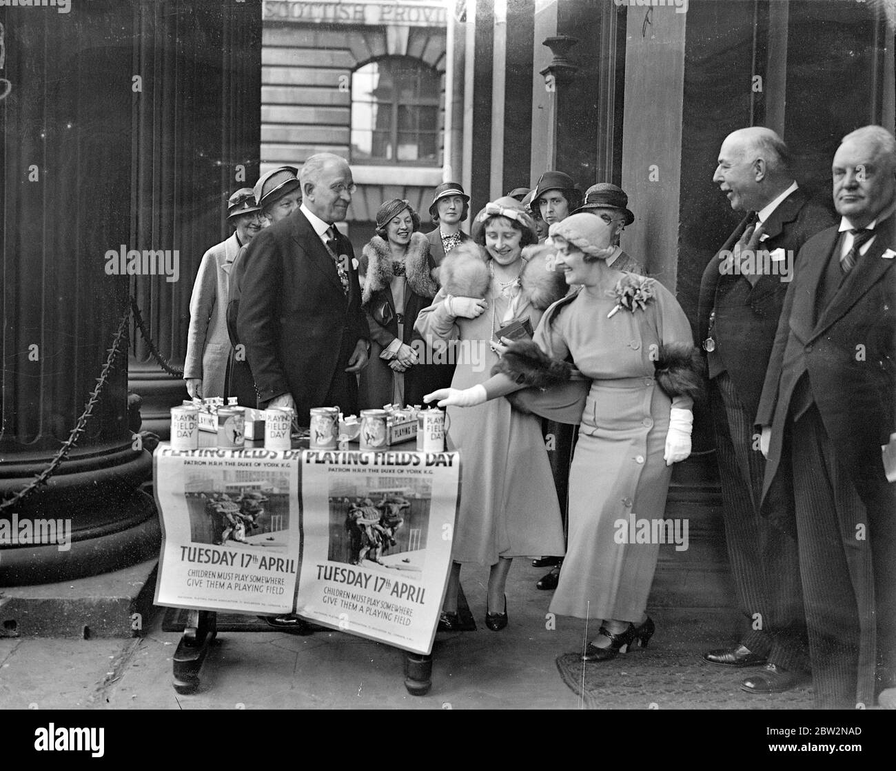 Duchessa di York al tour della Mansion House ' playing DIVs Day '. La Duchessa di York ha fatto un giro dei centri di distribuzione in connessione con ' Playing Fields Day ' che ha organizzato per raccogliere fondi per più campi da gioco . Durante il suo tour , la Duchessa chiamò a Mansion House . Spettacoli fotografici , la Duchessa di York che chiacchiera con i venditori sui gradini della Mansion House . Nel gruppo ci sono Lord Mayor , Sir Charles H Collett e Major Jackson , Presidente dell'associazione London Playing Fields . 17 aprile 1934 Foto Stock