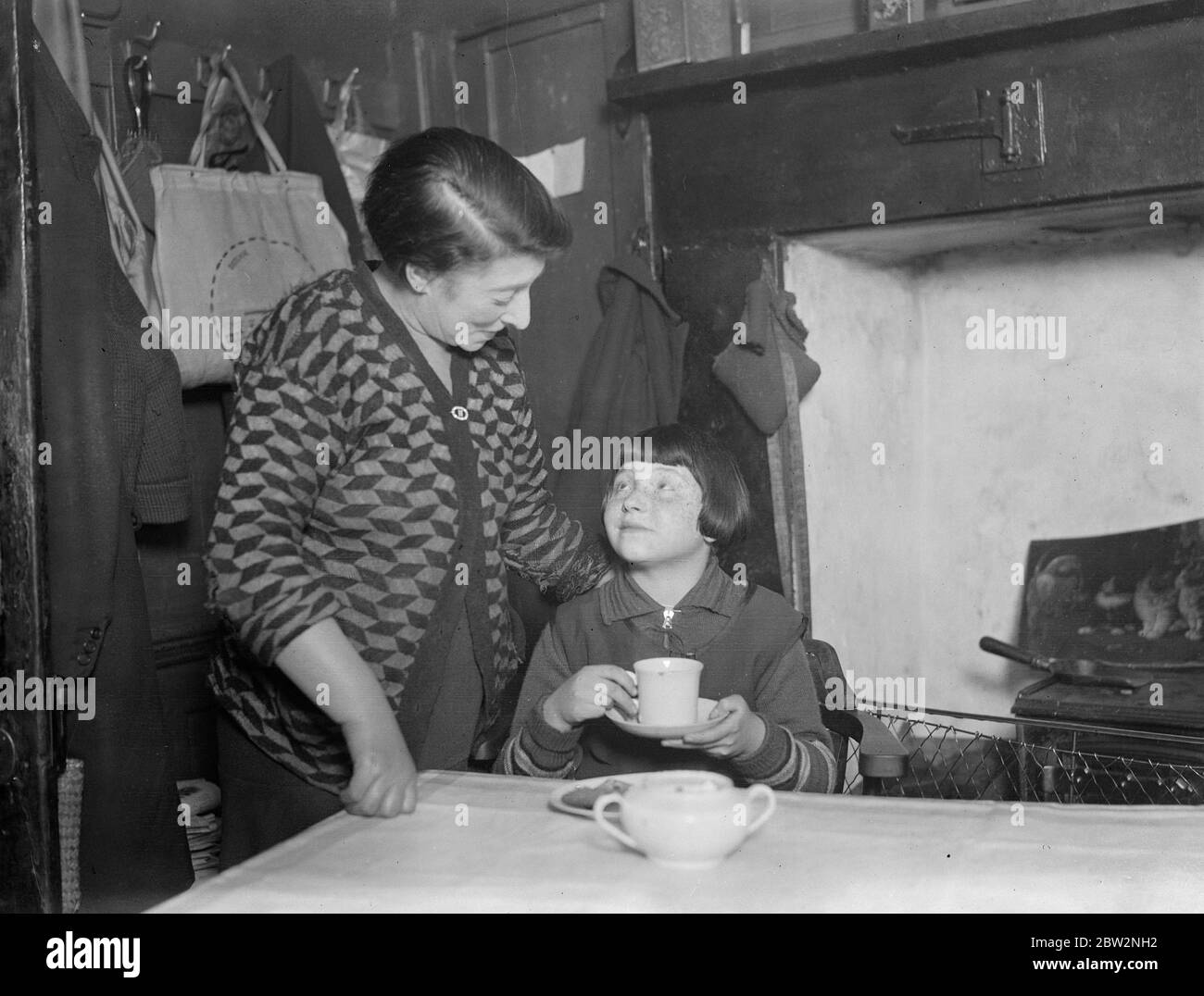 Eroina del dramma di fuoco di Whitechapel . Mary Levey , di 11 anni , era l' eroina di un incendio di notte in alta strada , Whitechapel . Era sola nell'edificio addormentato quando si svegliò per trovare la sua stanza piena di fumo . Venne trovata aggrappata alla finestra di una camera da letto al terzo piano dell'edificio nelle sue nightclothes , e fu salvata dai vigili del fuoco . Mary Levy con sua madre come lei ha avuto la sua colazione . 26 febbraio 1932 30s, 30s, 30s, 30s, 30s, trents, 19,trents Foto Stock