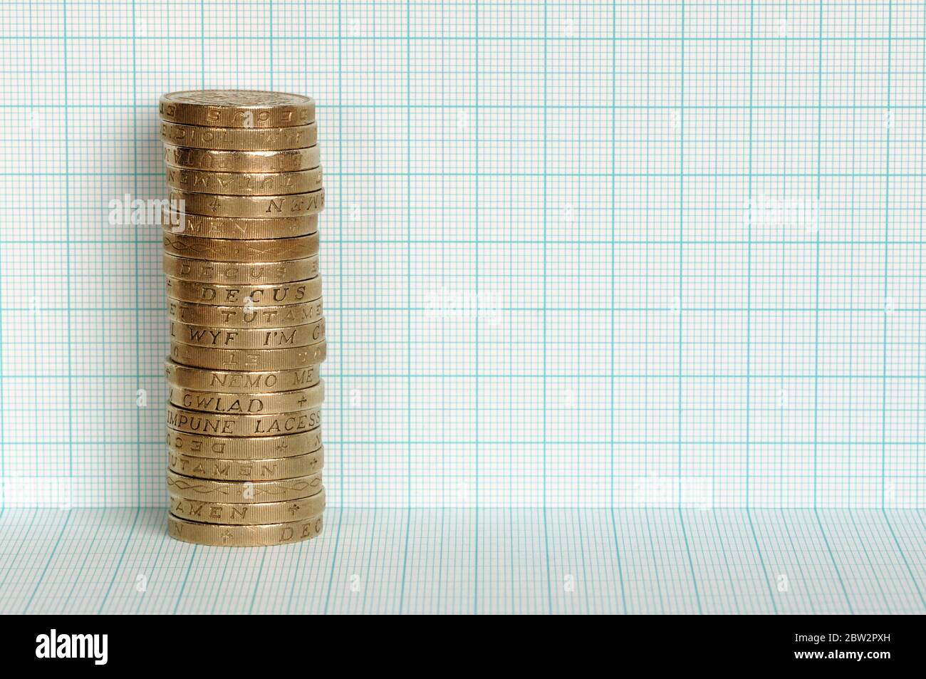 Una pila su monete da sterline contro un pezzo di carta grafica Foto Stock