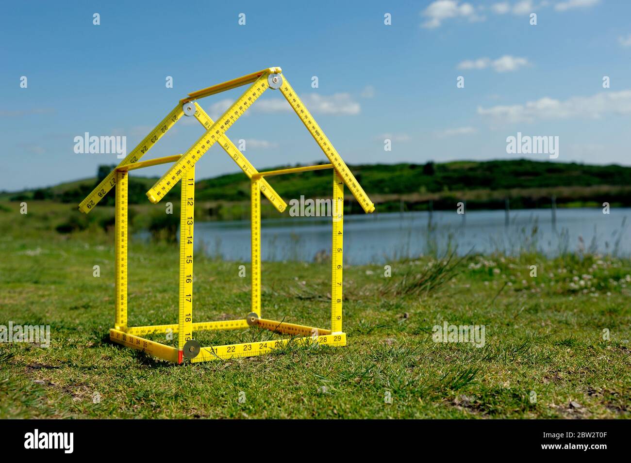 Una forma di casa posizionata su un terreno vicino ad un lago Foto Stock