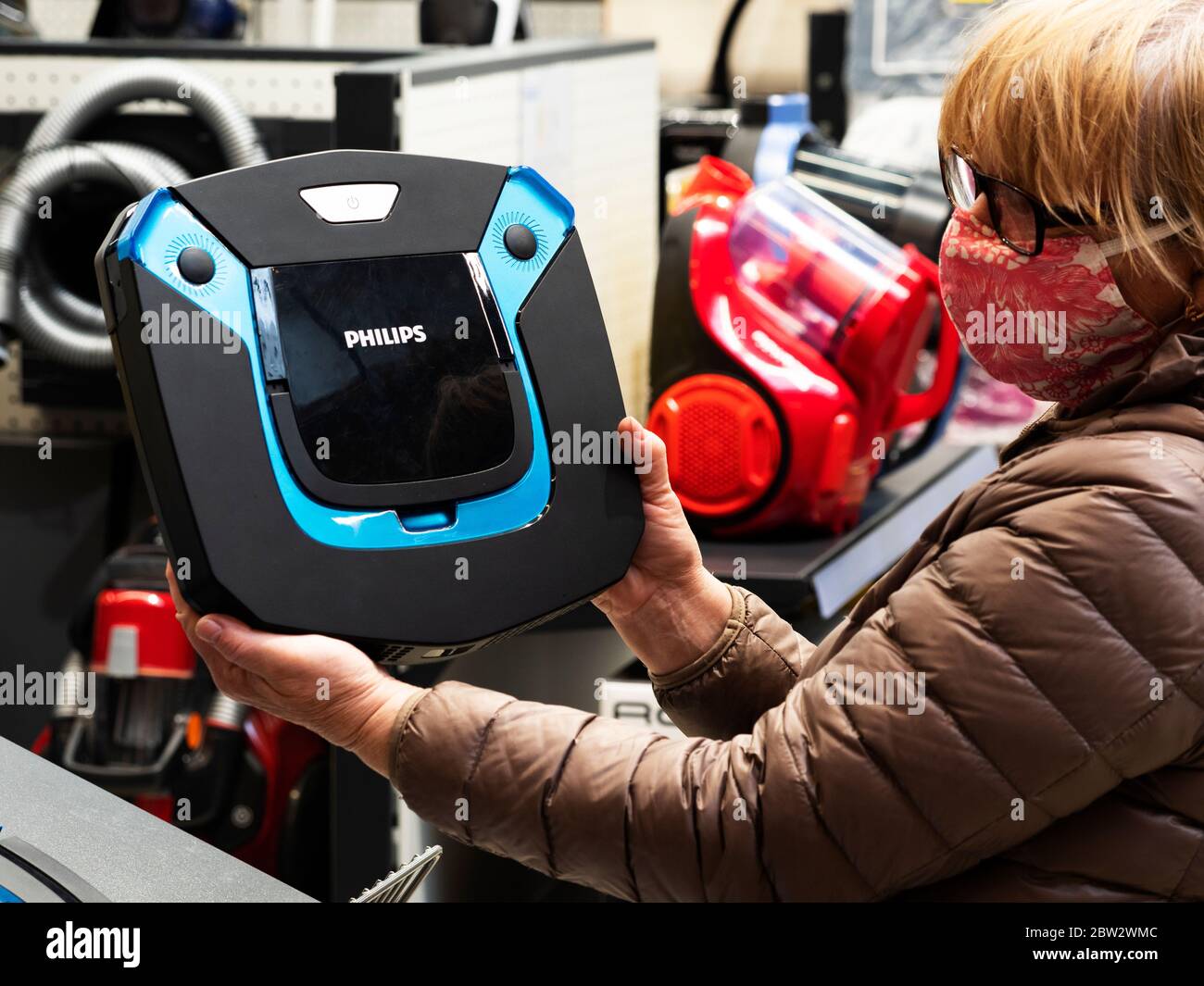 Donna tiene in mano un aspirapolvere-robot prodotto dalla multinazionale olandese Koninklijke Philips N.V. Foto Stock Donna tiene in mano un aspirapolvere-robot prodotto dalla multinazionale olandese Koninklijke Philips N.V. Foto Stock