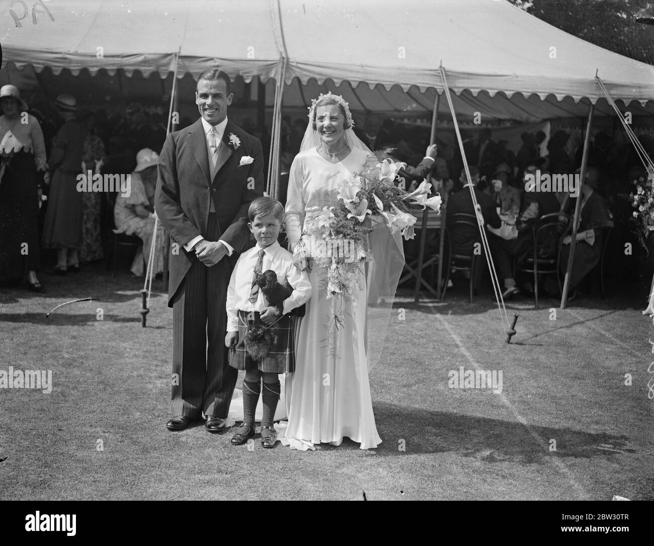 Gwen Sterry sposa rugby internazionale a Surbiton . La sig.na Gwen Sterry , il giocatore inglese di tennis da prato , è stata sposata con il sig. W M Simmers , il Rugby International scozzese , presso la chiesa di St Marks , Surbiton , Surrey . Un grande raduno di tennisti ha partecipato alla cerimonia e la signorina Betty Nuthall ha agito come una delle bridesmaids . La sposa e sposare con la pagina minuscola Maestro Hossack . 9 luglio 1932 Foto Stock