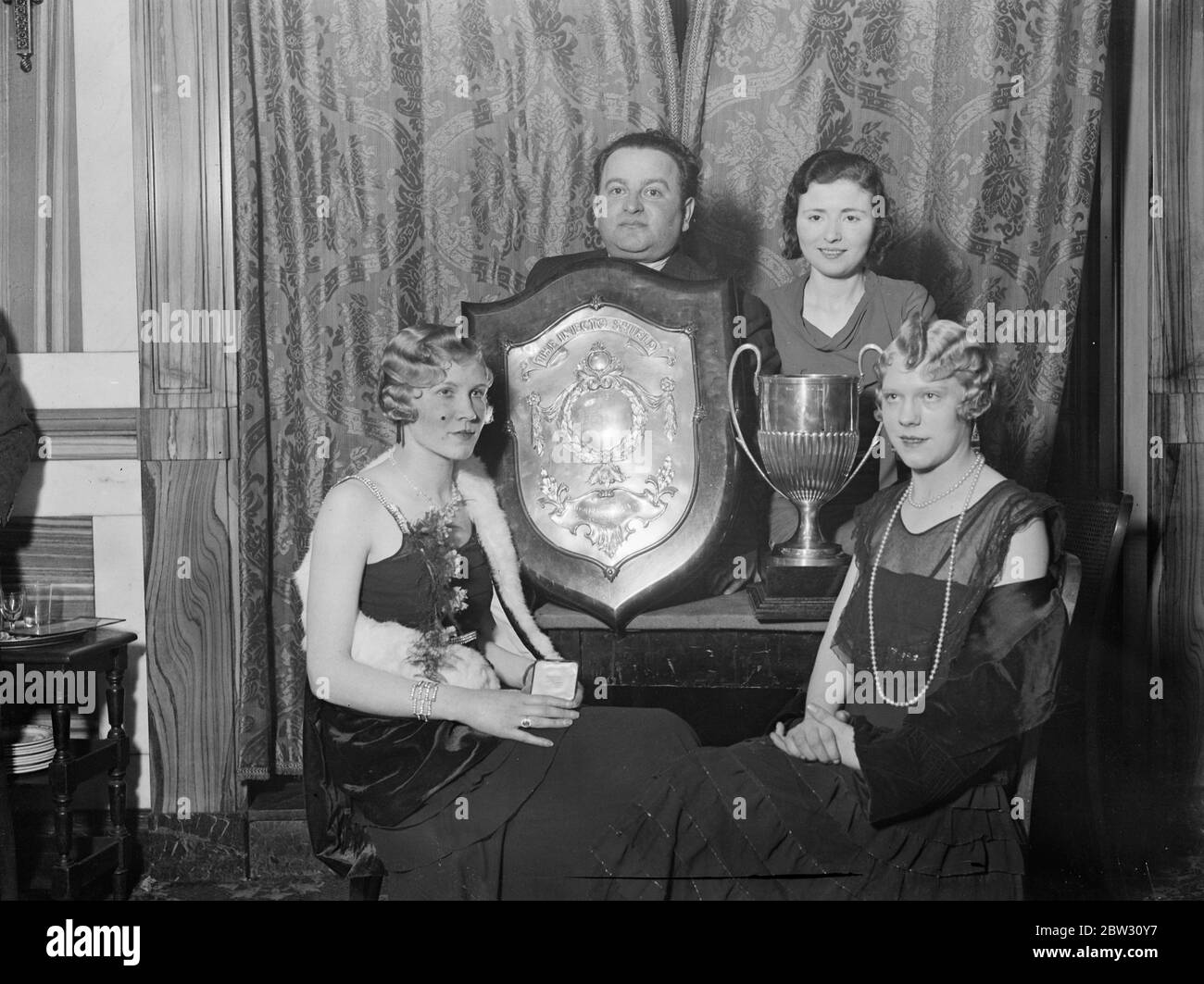 Campioni del mondo dell'acconciatura . La sig.ra Annette Ost è stata giudicata la donna campione parrucchiere e il sig. Alfred Balbus il parrucchiere uomo campione ad un concorso per le moda primaverili alla casa d'angolo di Lione , Londra . Il signor Alfred Balbus con il suo modello, la signora Edith Kelly (a sinistra) e lo scudo da campionato, e la signora Annette Ost con il suo modello, la signora Grace Walker e il suo trofeo , dopo il concorso . 8 marzo 1932 Foto Stock
