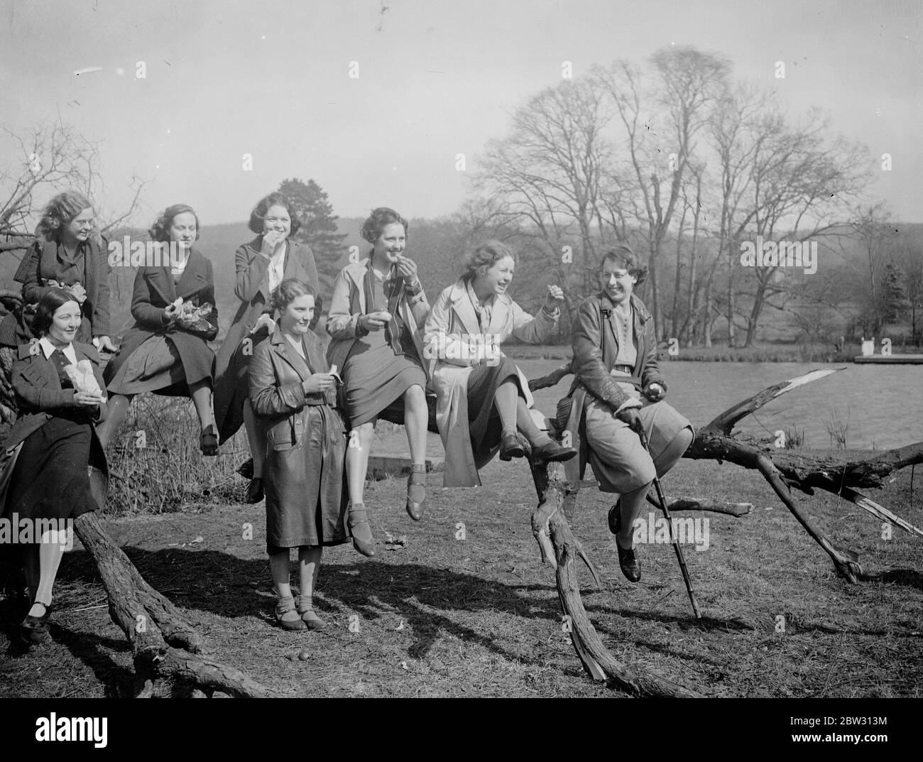 La gioia della strada a Pasqua . Girl escursionisti che viaggiavano nel Mystery Express escursionistico da Londra a Pangbourne , un posto di bellezza sul Tamigi , godendo di un riposo su un ramo vicino al vialetto sotto il sole primaverile . 25 marzo 1932 Foto Stock