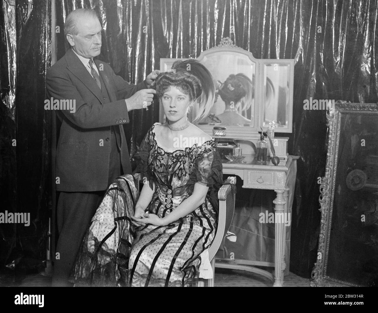 La modalità 1900 ritorna alla città . Parrucchieri in tutta Inghilterra stanno preparando modelli per una mostra di parrucchiere durante le età che si terrà a Londra . M Adolphe , un parrucchiere londinese , preparando il suo modello , la signorina Rosslyn Taylor , che rappresenterà una signora vittoriana dell' anno 1900 . 4 febbraio 1932 Foto Stock