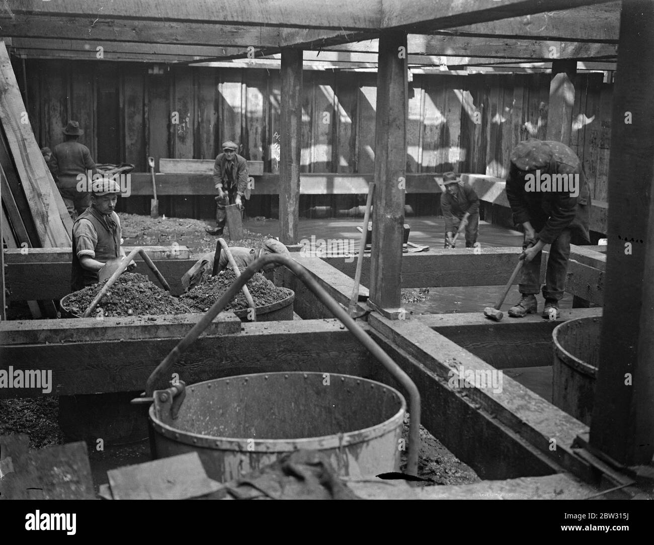 Edificio Richmond bridge, immagine dal letto del fiume. Un nuovo ponte di cemento è in costruzione sul Tamigi a Richmond , vicino al Parco del Vecchio Cervo , e migliaia di tonnellate di cemento sono in uso nel lavoro , Che è una delle più grandi imprese di costruzione di ponti in cemento mai tentate in Inghilterra . il letto del fiume è stato scavato per mezzo di dighe di caffè . Scavare il letto del Tamigi in dighe di caffè per le fondazioni e i moli del nuovo ponte di Richmond . 9 marzo 1932 Foto Stock