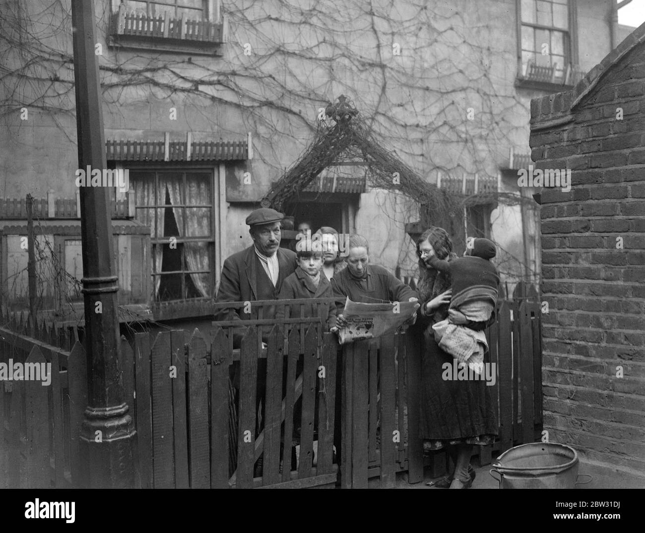 Principe di Galles nel East End . Il Principe del Galles ha visitato le povere case dell' East End di Londra per vedere da solo come vivono i poveri in una zona di baraccie , in una casa che ha visitato , Quella della signora Livesey in Park Place , Stratford , stava lavando i piedi dal fuoco con il suo bambino sul ginocchio . Ha visitato anche la casa del signor e della signora Easy e dei loro figli , dove il principe ammirava i fiori coltivati dal signor Easy , appassionato di giardinaggio dilettante . Il signor e la signora Easy e i bambini nel loro giardino d'ingresso , che il principe ammirava , chiacchierano con la signora Livesey e il suo bambino sulla visita del principe Foto Stock