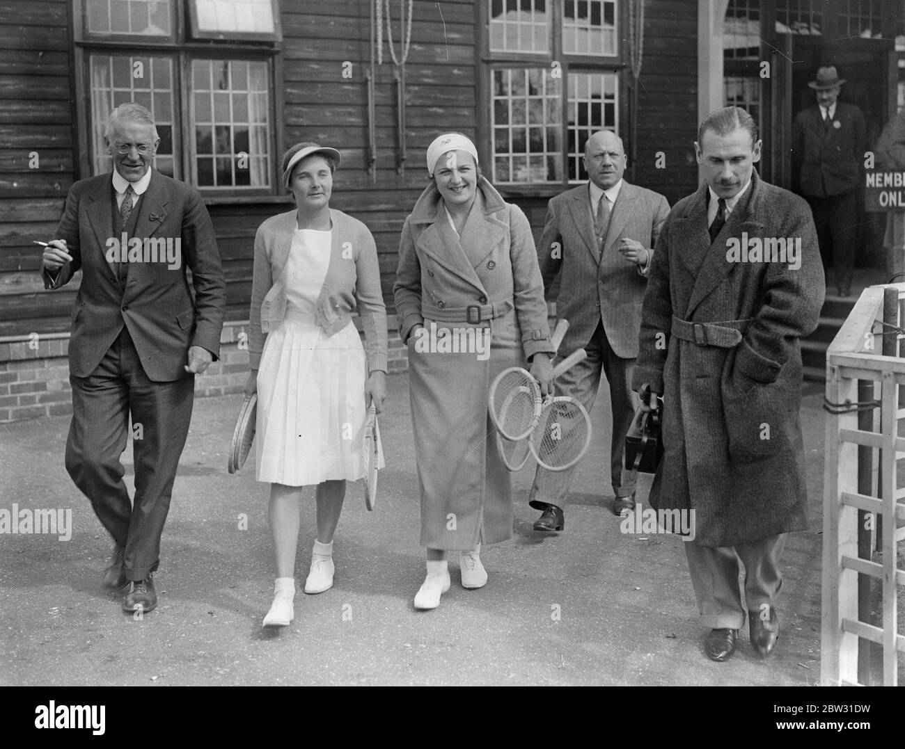 Betty Nuthall sconfigge la nuova stella del tennis , Miss Trammers dimentica i suoi vestiti . Miss Betty Nuthall il giovane campione di tennis su prato , difese con successo il suo prestigio contro Miss Kathleen Stammers , la nuova arrivata di tutti conquistando il grande tennis quando si incontrarono nel campionato nazionale di tennis dei campi duri a Bournemouth . Il primo turno fu una farsa , Miss Nuthall vincendo un amore su due faglie , ma Miss Stammer si tirò in su nel secondo set per livellare il suo avversario con 5 giochi tutti , solo per perdere 5-0 , 7-5 . Il gioco è stato tenuto in su per un certo tempo mentre Miss Stammers ha tratteggiato in una macchina per prendere il suo clo di tennis Foto Stock