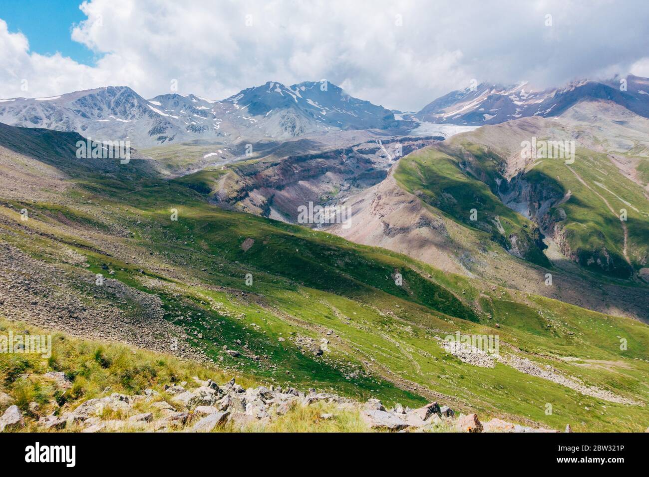Le nuvole gettano forme e ombre irregolari sul monte Kazbek, sulle montagne del Caucaso, Georgia Foto Stock