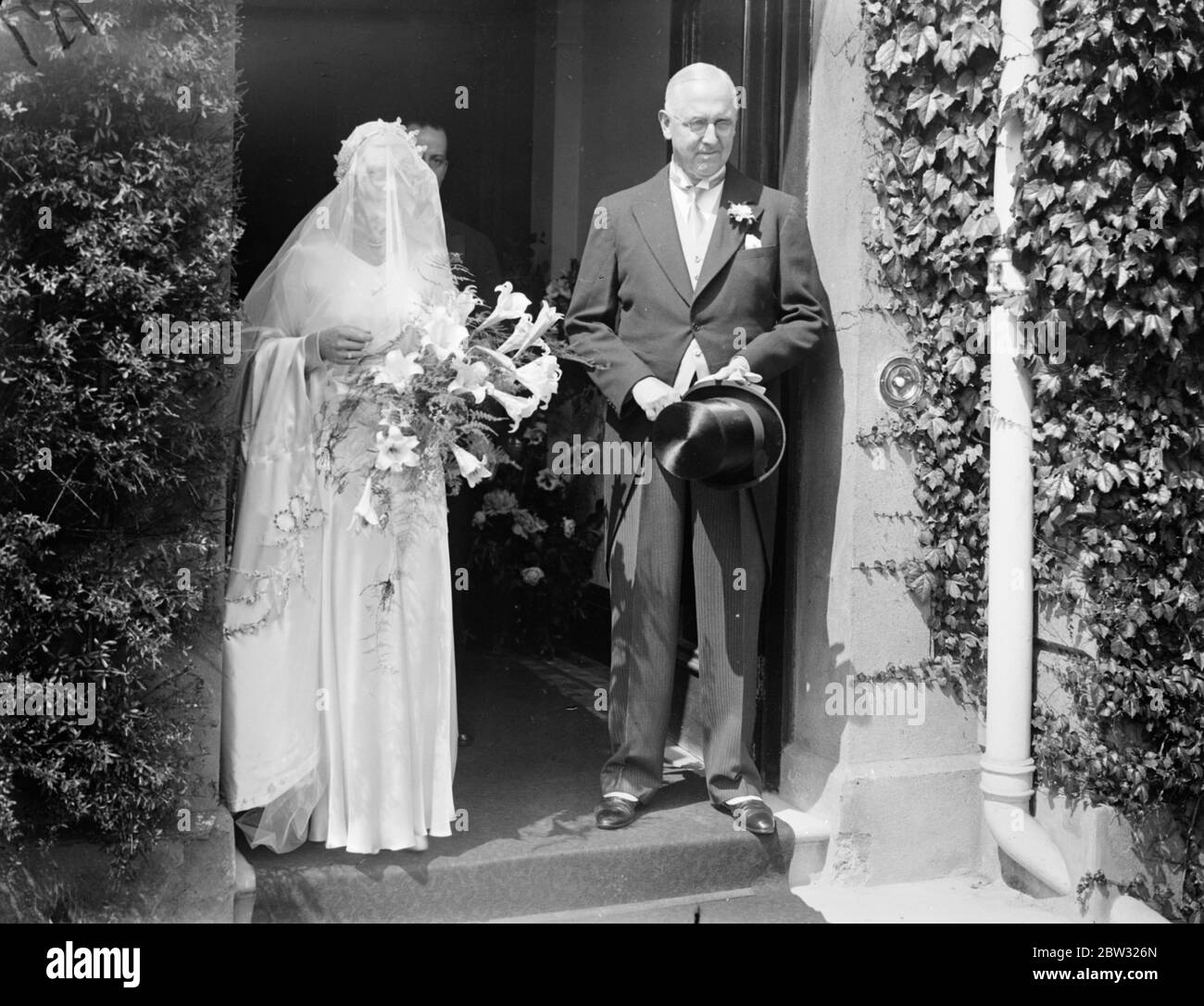 Gwen Sterry sposa rugby internazionale a Surbiton . La sig.na Gwen Sterry , il giocatore inglese di tennis da prato , è stata sposata con il sig. W M Simmers , il Rugby International scozzese , presso la chiesa di St Marks , Surbiton , Surrey . Un grande raduno di tennisti ha partecipato alla cerimonia e la signorina Betty Nuthall ha agito come una delle bridesmaids . Lo sposo e lo sposo . 9 luglio 1932 Foto Stock