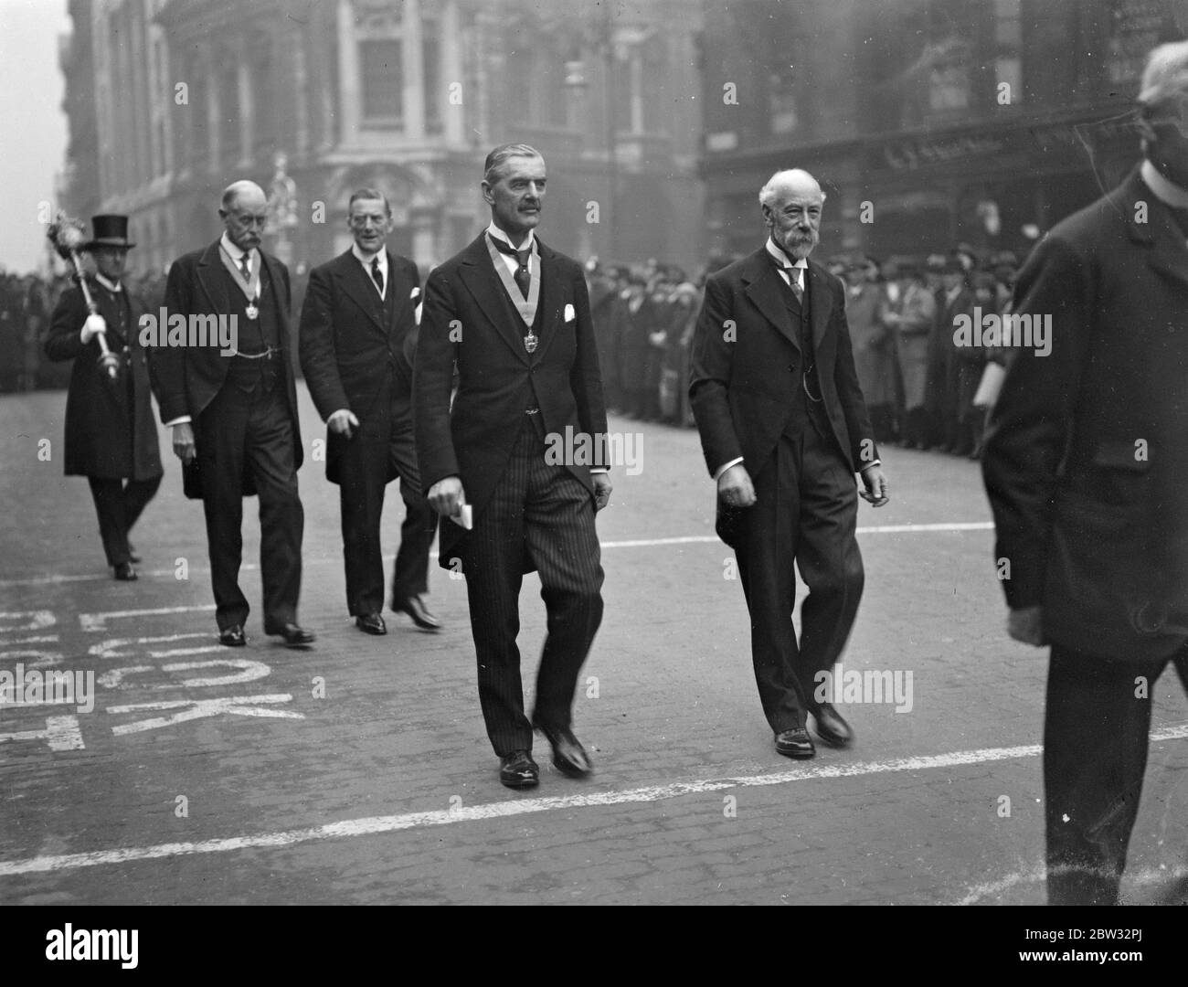Il Cancelliere dello scacchiere riceve la libertà di Birmingham . Il Cancelliere dello scacchiere ha ricevuto la libertà della città di Birmingham in un groviglio d'argento , in occasione di una riunione speciale del Consiglio nel Municipio di Birmingham . La processione che lascia la Casa del Consiglio per il Municipio, davanti, al Rt Hon Neville Chamberlain (a sinistra) e al Barrow Cadbury Eaqe, JP. Alle spalle : Alderman John Henry Lloyd JP (a sinistra) e Sir Austen Chamberlain . 6 maggio 1932 Foto Stock