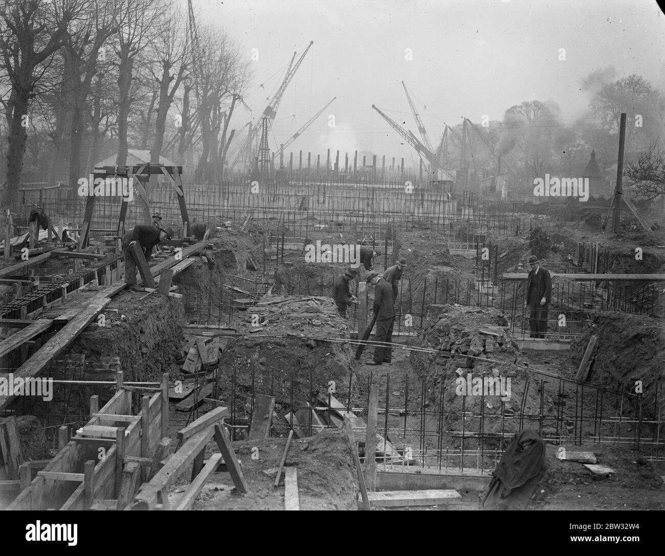 Nuovo ponte in cemento sul Tamigi a Richmond . Un nuovo ponte di cemento è in costruzione sul Tamigi a Richmond , vicino al Parco del Vecchio Cervo , e migliaia di tonnellate di calcestruzzo sono in uso nel lavoro , che è una delle più grandi imprese di costruzione di calcestruzzo mai tentate in Inghilterra . Il letto del fiume è stato scavato per mezzo di dighe di caffè . La massa di ferri di rinforzo in acciaio per rinforzare il calcestruzzo del nuovo ponte di Richmond . 9 marzo 1932 Foto Stock