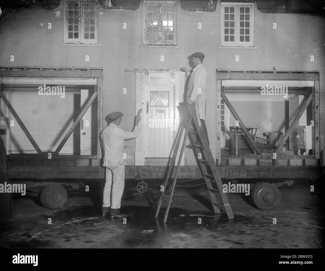 Riparazione della casa modello della principessa Elisabetta all'Olimpia . Subito dopo essere arrivati all' Olympia , Londra , la casa modello danneggiata presentata alla principessa Elisabetta dal popolo del Galles a Cardiff la scorsa settimana , che è stata danneggiata dal fuoco quando è stata portata in strada a Londra , i lavoratori hanno iniziato a lavorare per ripristinare il modello . Casa modello della principessa Elisabetta in riparazione all' Olympia , Londra . 23 marzo 1932 Foto Stock