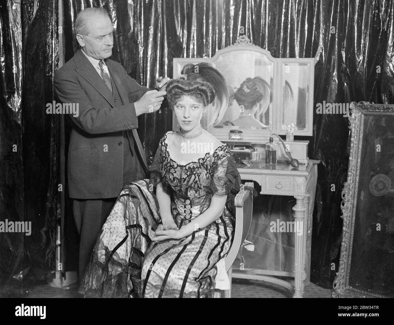 La modalità 1900 ritorna alla città . Parrucchieri in tutta Inghilterra stanno preparando modelli per una mostra di parrucchiere durante le età che si terrà a Londra . M Adolphe , un parrucchiere londinese , preparando il suo modello , la signorina Rosslyn Taylor , che rappresenterà una signora vittoriana dell' anno 1900 . 4 febbraio 1932 Foto Stock