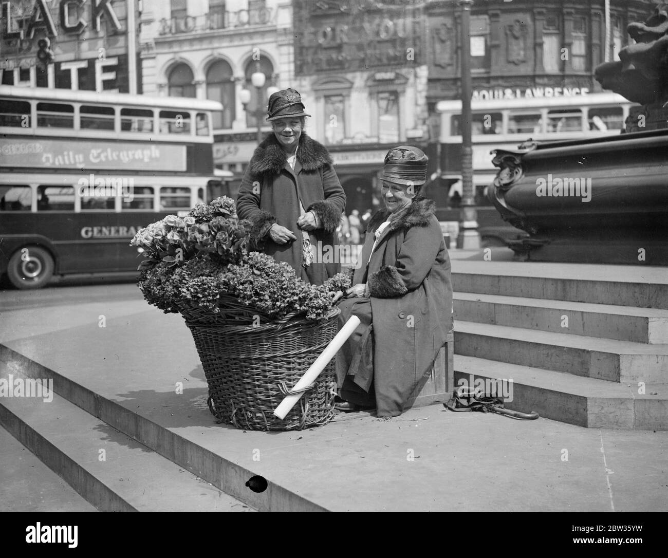 Piccadilly fiore ragazze per partecipare alla palla di fiori della società . Polly e nell , che hanno venduto i loro fiori sotto la statua di Eros a Piccadilly Circus , Londra , per anni , saranno gli ospiti di centinaia di persone della società ben conosciute che frequentano la Flower Ball . Saranno accolti da Lady Carisbrooke , figlia - in - legge della principessa Beatrice e una Eros in miniatura sarà eretto nella sala da ballo per farli sentire ' a casa '. Polly e nell si dice siano le ragazze di fiori più famose del mondo . Polly Beecham ( seduto ) e nell ( Lizzie Sanger ) , fotografati sotto Eros a Piccadil Foto Stock