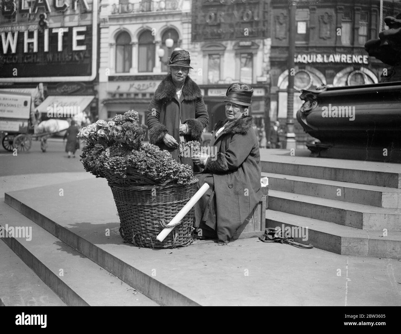 Piccadilly fiore ragazze per partecipare alla palla di fiori della società . Polly e nell , che hanno venduto i loro fiori sotto la statua di Eros a Piccadilly Circus , Londra , per anni , saranno gli ospiti di centinaia di persone della società ben conosciute che frequentano la Flower Ball . Saranno accolti da Lady Carisbrooke , figlia - in - legge della principessa Beatrice e una Eros in miniatura sarà eretto nella sala da ballo per farli sentire ' a casa '. Polly e nell si dice siano le ragazze di fiori più famose del mondo . Polly Beecham ( seduto ) e nell ( Lizzie Sanger ) , fotografati sotto Eros a Piccadil Foto Stock