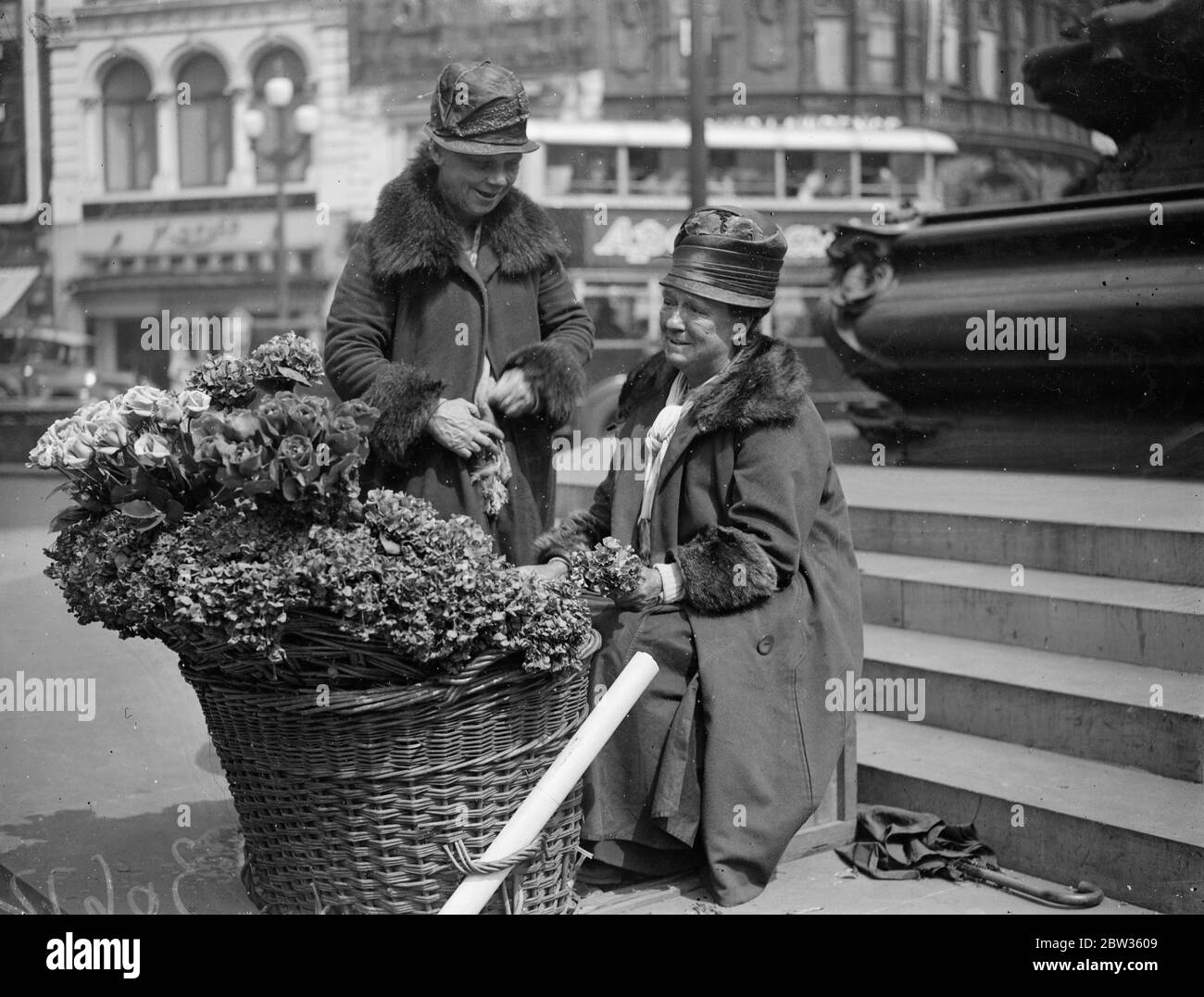 Piccadilly fiore ragazze per partecipare alla palla di fiori della società . Polly e nell , che hanno venduto i loro fiori sotto la statua di Eros a Piccadilly Circus , Londra , per anni , saranno gli ospiti di centinaia di persone della società ben conosciute che frequentano la Flower Ball . Saranno accolti da Lady Carisbrooke , figlia - in - legge della principessa Beatrice e una Eros in miniatura sarà eretto nella sala da ballo per farli sentire ' a casa '. Polly e nell si dice siano le ragazze di fiori più famose del mondo . Polly Beecham ( seduto ) e nell ( Lizzie Sanger ) , fotografati sotto Eros a Piccadil Foto Stock
