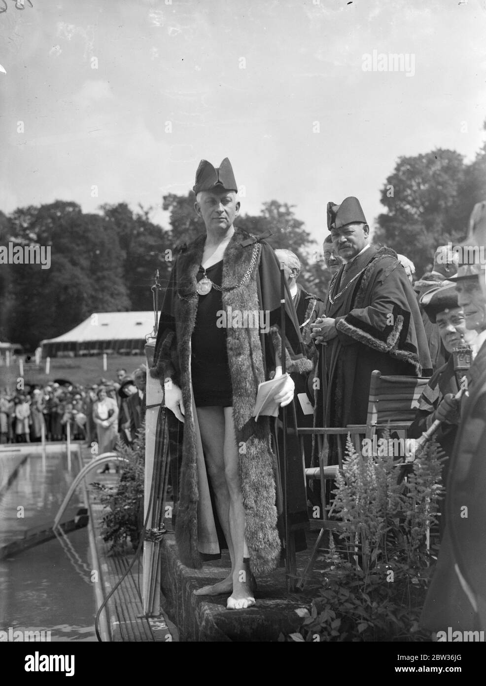 Il sindaco di Guildford ( Alderman William Harvey ) ha fatto il primo tuffo all' apertura della nuova piscina di Guilford, £13 , 000, a Stoke Park . Ha eseguito la cerimonia indossando i suoi abiti su un costume da bagno . Quando la sua testa riapparve sulla superficie dei membri dell'acqua della Società e del pubblico generale fece uno spruzzi di comunità . Spettacoli fotografici ; il Sindaco di Guildford pronto ad immergersi per aprire la nuova piscina . 21 giugno 1933 Foto Stock