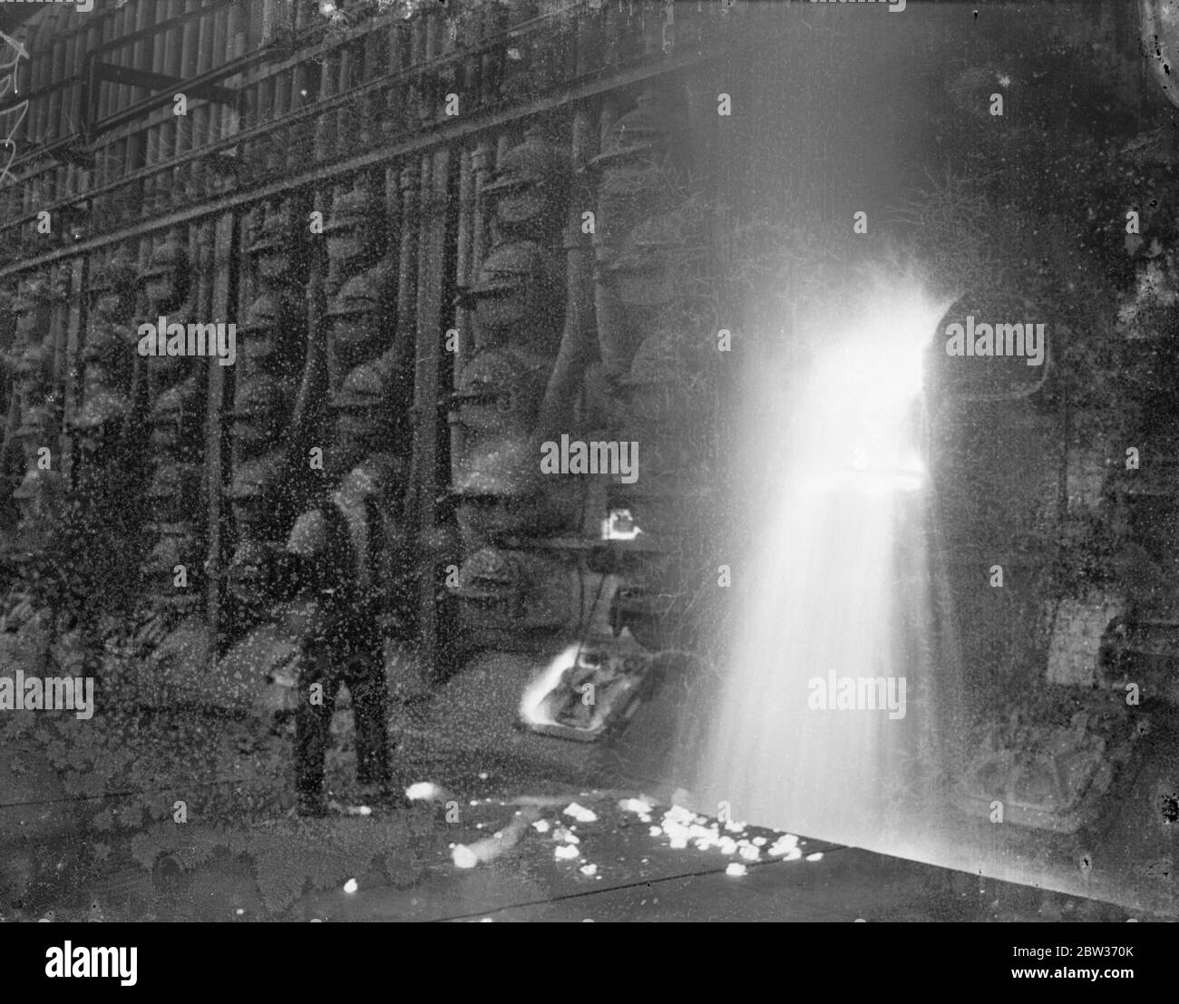 Il lavoro più caldo in una Londra tremendo . Mentre la maggior parte dei londinesi tremava nel freddo tempo della verruca , quest'uomo alla Beckton Works della gas , della luce e della compagnia di coke si è soffermato nel calore . Viene fotografato dal riflesso della fornace mentre scarica una replica . 4 dicembre 1933 Foto Stock