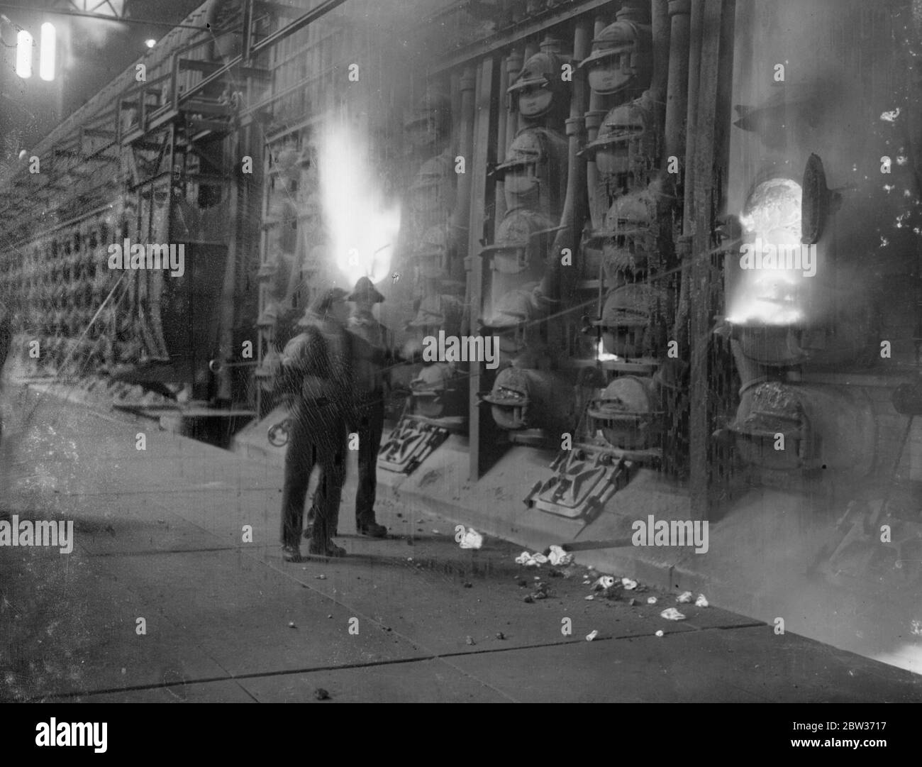 Il lavoro più caldo in una Londra tremendo . Mentre la maggior parte dei londinesi tremava nel freddo tempo della verruca , quest'uomo alla Beckton Works della gas , della luce e della compagnia di coke si è soffermato nel calore . Viene fotografato dal riflesso della fornace mentre scarica una replica . 4 dicembre 1933 Foto Stock