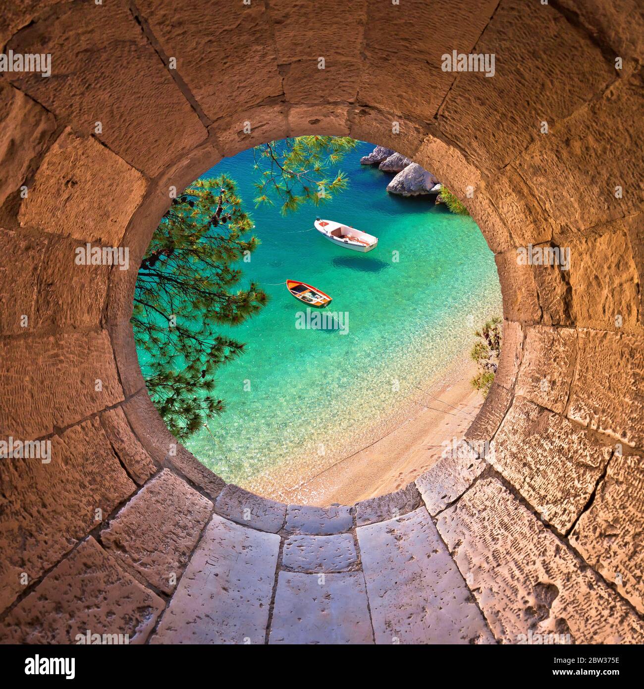 Spiaggia di Hiden a Brela con barche sul mare smeraldo vista aerea attraverso finestra in pietra, Makarska riviera della Dalmazia, Croazia Foto Stock