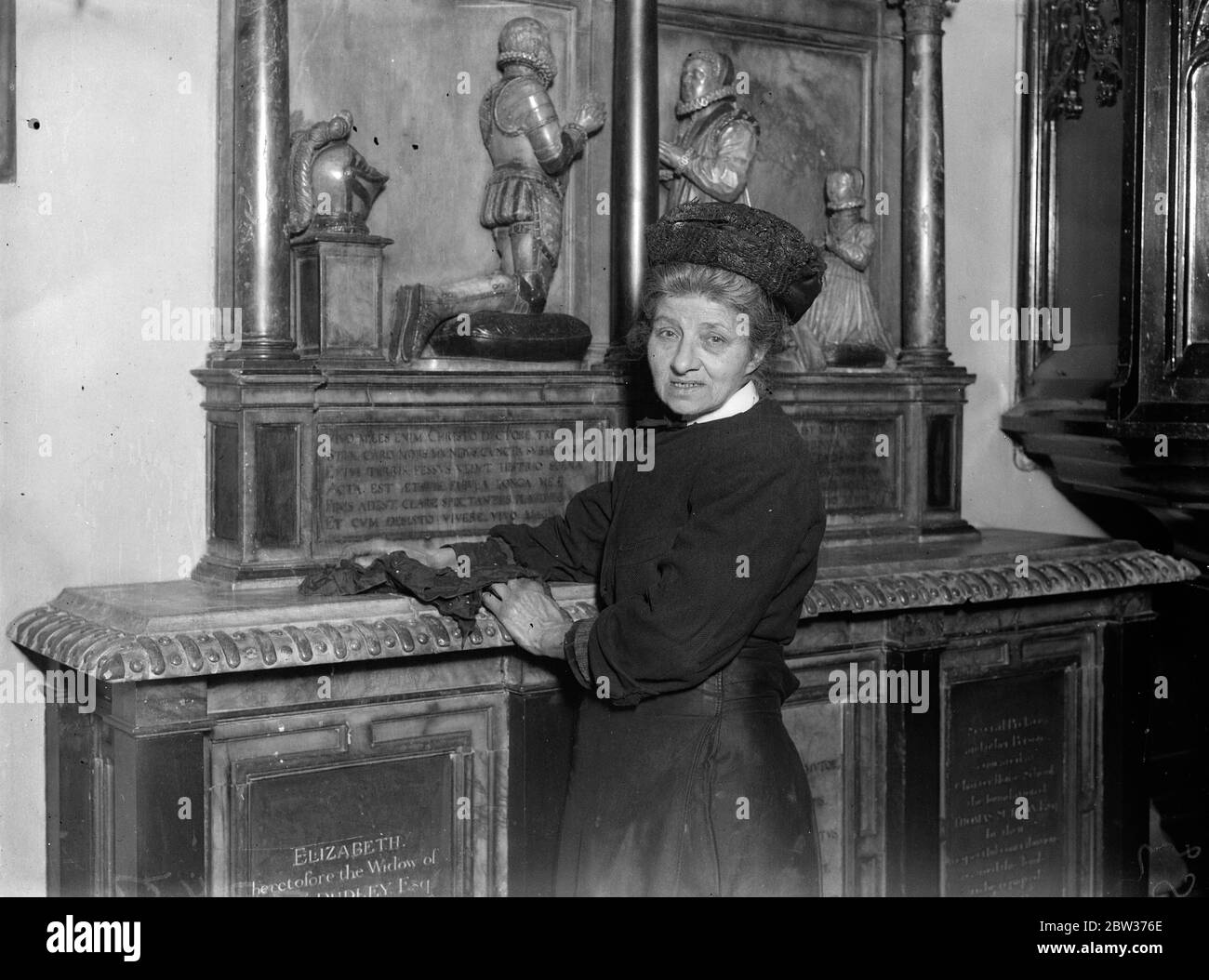Donna verger che è stata presentata alla Regina . Quando la Regina visitò la vecchia chiesa parrocchiale di St Mary' , Stoke Newington , Miss Carrie Houcher , le fu presentato il 66 anni verger . La Regina visitò la Chiesa dopo aver visto un centro disoccupato locale . Quando la sig.ra Houcher si è avanzata per essere presentata ha tenuto un antipolvere in sua mano . Foto spettacoli ; Miss Carrie Houcher alla tomba di Thomas Sutton , il fondatore della Certosa , morto nel 1602 . Questa fu la tomba in cui la Regina mostrò particolare interesse durante la sua visita alla Chiesa . 14 dicembre 1933 Foto Stock