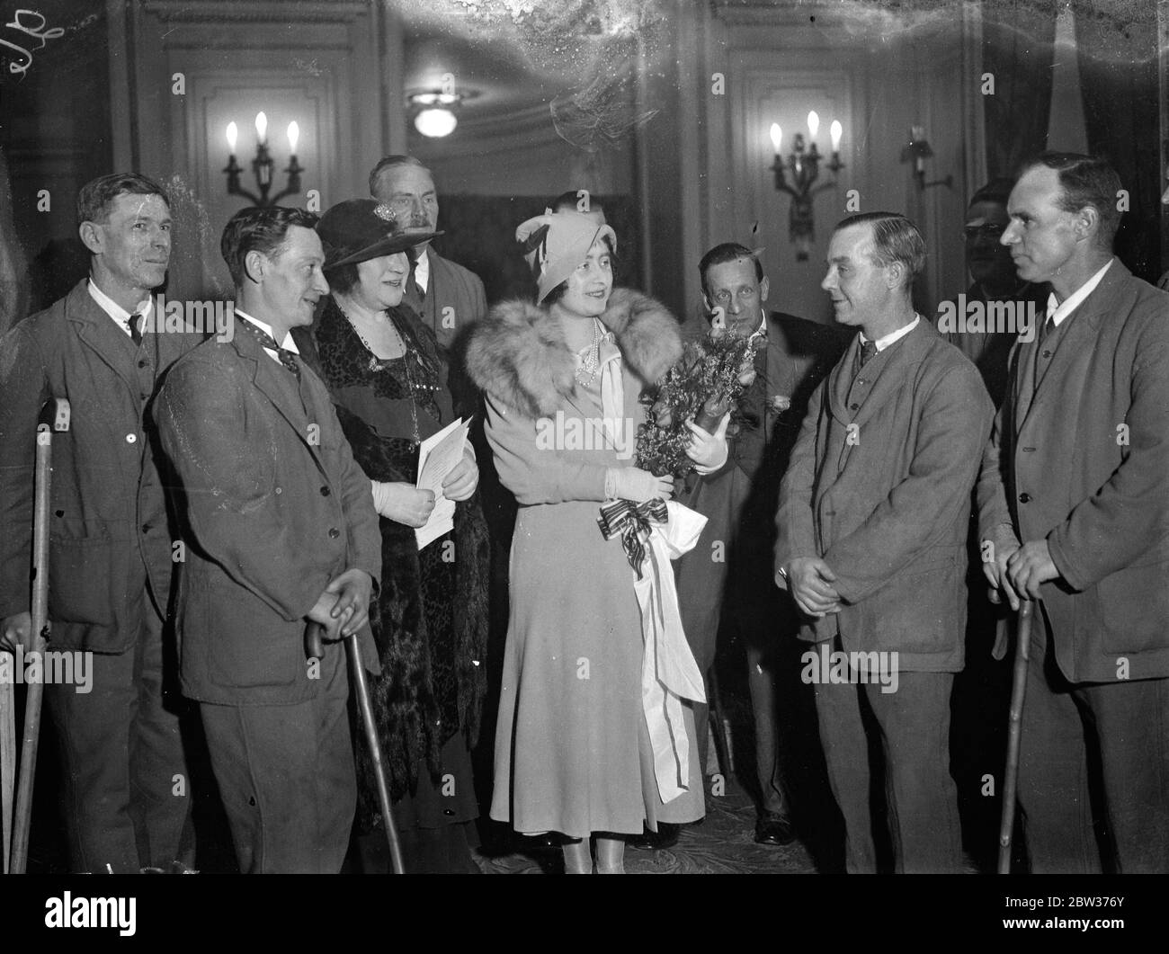 Duchessa di York tra ex-servicemen . La Duchessa di York ha partecipato al trasferimento annuale dei fondi della non Forgotten Association tenutosi presso l'Hyde Park Hotel di Knightsbridge , Londra . Foto mostra ; la duchessa di York che parla con l'ex - servicemen appena ricevuto il suo bouquet da loro . 11 dicembre 1933 Foto Stock