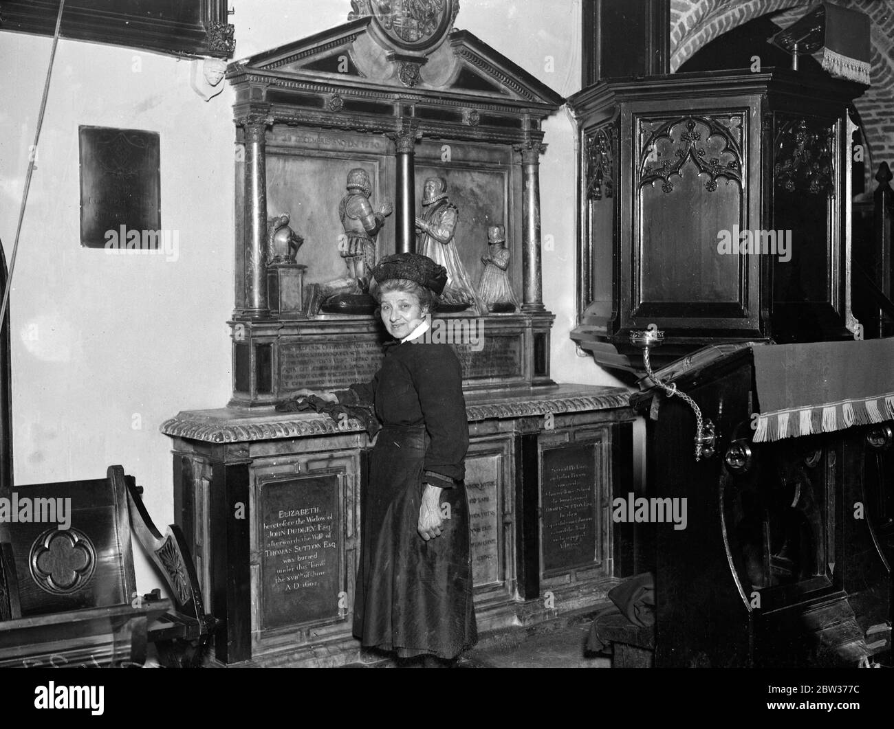 Donna verger che è stata presentata alla Regina . Quando la Regina visitò la vecchia chiesa parrocchiale di St Mary' , Stoke Newington , Miss Carrie Houcher , le fu presentato il 66 anni verger . La Regina visitò la Chiesa dopo aver visto un centro disoccupato locale . Quando la sig.ra Houcher si è avanzata per essere presentata ha tenuto un antipolvere in sua mano . Foto spettacoli ; Miss Carrie Houcher alla tomba di Thomas Sutton , il fondatore della Certosa , morto nel 1602 . Questa fu la tomba in cui la Regina mostrò particolare interesse durante la sua visita alla Chiesa . 14 dicembre 1933 Foto Stock