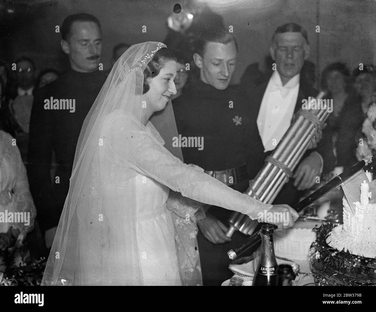 Una guardia d'onore delle magliette ha partecipato al matrimonio alla Chiesa di San Michele , Chester Square , Londra di Ian Hope Dundas , capo di stato maggiore dell'Unione britannica dei fascisti e di Miss Pamela Ernestin Dorman , anch'essa fascista . Sir Oswald Mosley , leader dell' Unione britannica dei fascisti , era il migliore uomo alla cerimonia . Il signor Dundas e figlio del defunto ammiraglio Sir Charles Dundas di Inchgarbie House, South Queensferry, Scozia. La sposa è una nipote del compianto Sir Ernest Shackleton , l' esploratore antartico . Spettacoli fotografici ; la sposa tagliando la torta con un'acatona guardata da Sir Oswald Foto Stock