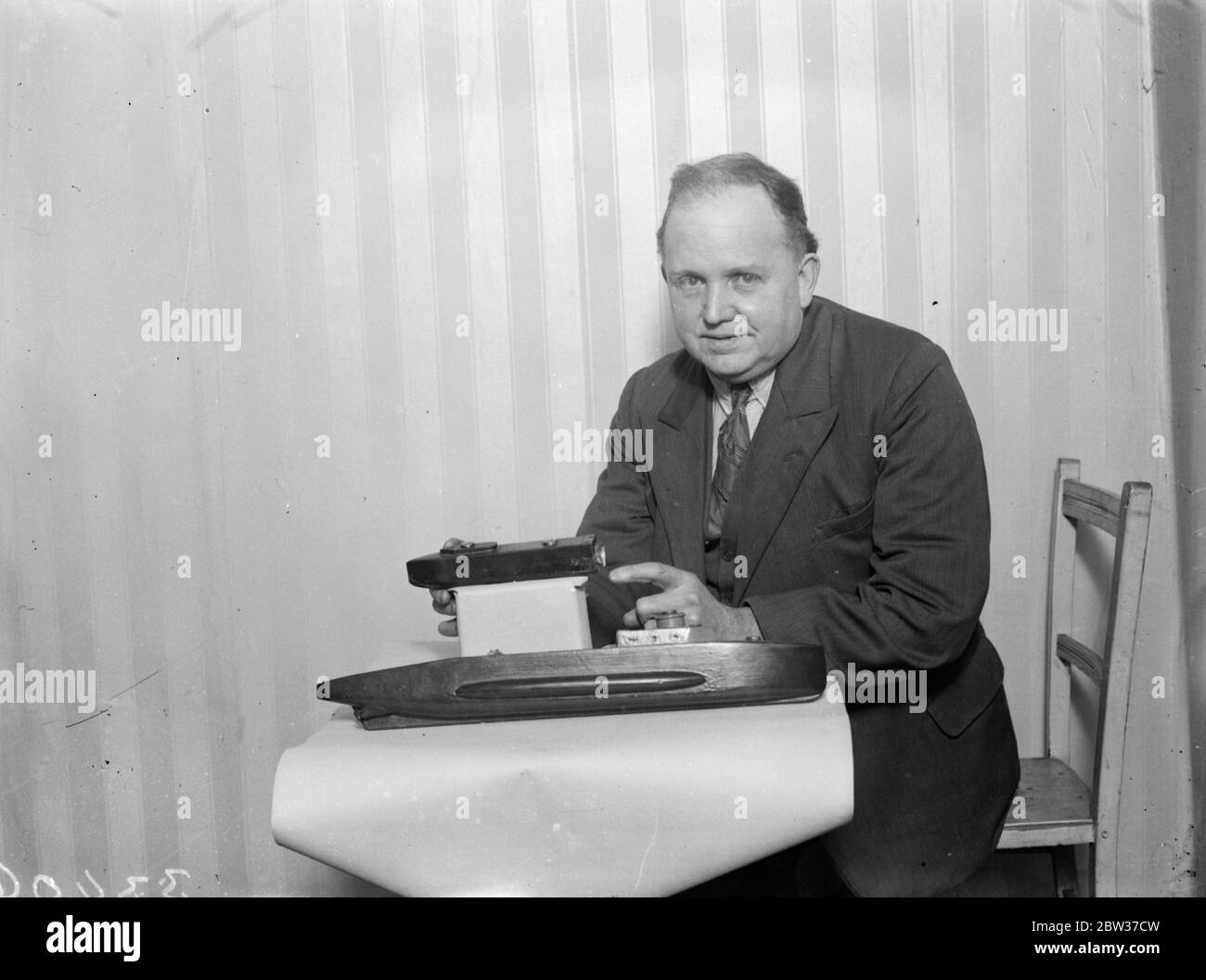 L'ingegnere londinese dice che il suo dispositivo salverà tutto in sottomarino sommerso . Dock galleggiante per trasportare un vaso per bambini . Walter Paddon , ex capo ingegnere del servizio mercantile che vive a Bayswater , Londra , sostiene di poter salvare la vita di ogni membro dell' equipaggio in un disastro sottomarino . Ha costruito un modello di sottomarino in legno . È lunga due piedi . Un sottomarino per bambini di un quarto delle sue dimensioni si trova in un molo galleggiante sul suo ponte . Il signor Paddon ha fatto appello alla sua invenzione la camera di sicurezza staccabile di Paddon. Dice che avrebbe permesso ad un equipaggio di 100 uomini di lasciare un sommergibile sommerso e venire al sur Foto Stock