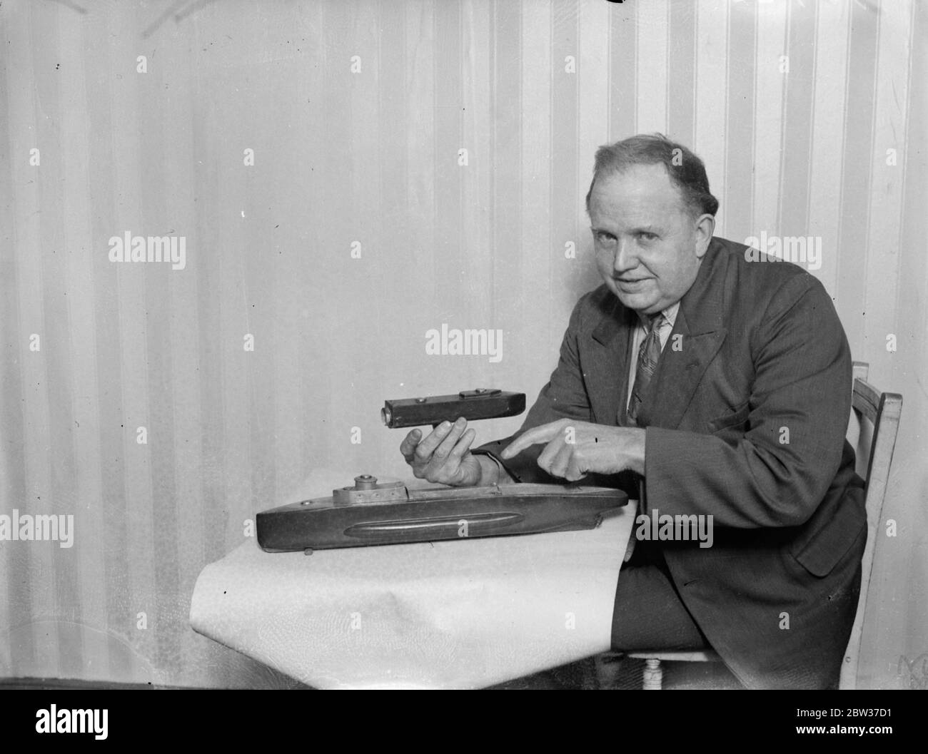 L'ingegnere londinese dice che il suo dispositivo salverà tutto in sottomarino sommerso . Dock galleggiante per trasportare un vaso per bambini . Walter Paddon , ex capo ingegnere del servizio mercantile che vive a Bayswater , Londra , sostiene di poter salvare la vita di ogni membro dell' equipaggio in un disastro sottomarino . Ha costruito un modello di sottomarino in legno . È lunga due piedi . Un sottomarino per bambini di un quarto delle sue dimensioni si trova in un molo galleggiante sul suo ponte . Il signor Paddon ha fatto appello alla sua invenzione la camera di sicurezza staccabile di Paddon. Dice che avrebbe permesso ad un equipaggio di 100 uomini di lasciare un sommergibile sommerso e venire al sur Foto Stock