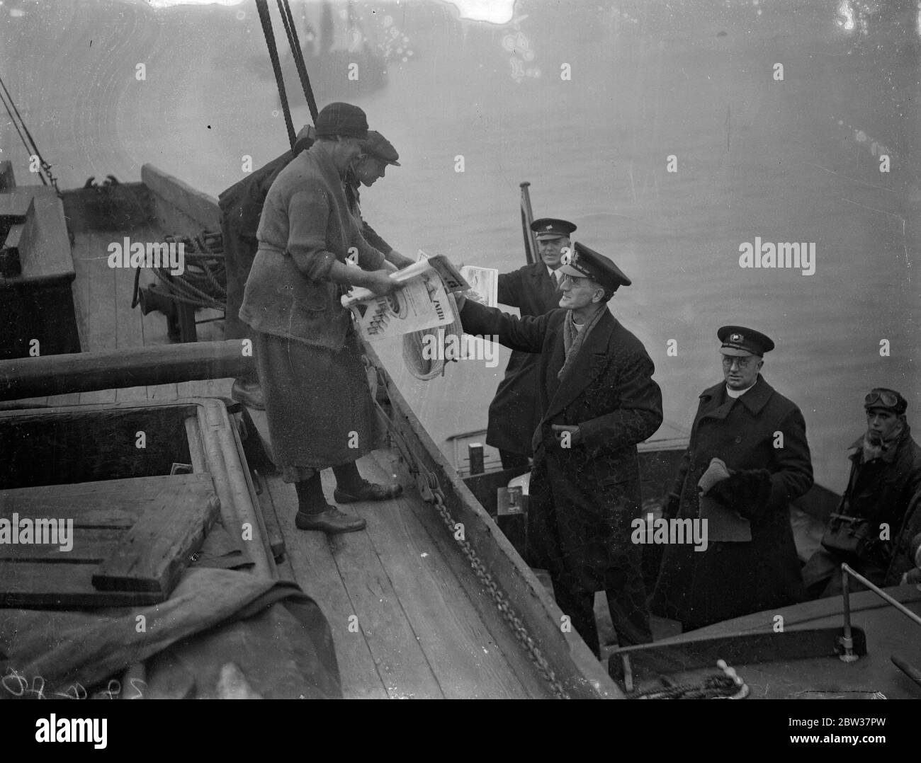 Distribuzione di regali di natale agli acquieri del Tamigi . La distribuzione annuale dei regali di Natale agli acquieri del Tamigi da parte delle missioni ai marinai ha avuto luogo sul fiume quando il reverendo F J Cutts ha distribuito i regali. Spettacoli fotografici ; il reverendo F H Cutts distribuisce regali a una collier Sunderland sul Tamigi vicino a Woolwich . 21 dicembre 1933 Foto Stock