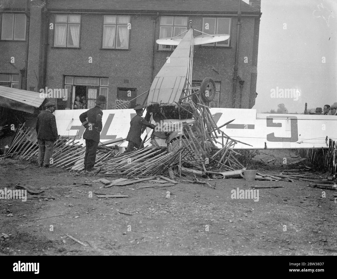 Due sono stati portati in ospedale quando l'aereo si schianta in casa dopo aver lasciato l'aeroporto . Un aereo che aveva appena lasciato l'Aerodromo di Hanworth si schiantò in una recinzione e colpì il retro di una casa . La macchina quindi ribaltata . Un passeggero è stato buttato fuori e due occupanti sono stati portati in ospedale . Foto mostra , l'aereo nel giardino della casa dopo l'incidente . 9 maggio 1934 Foto Stock