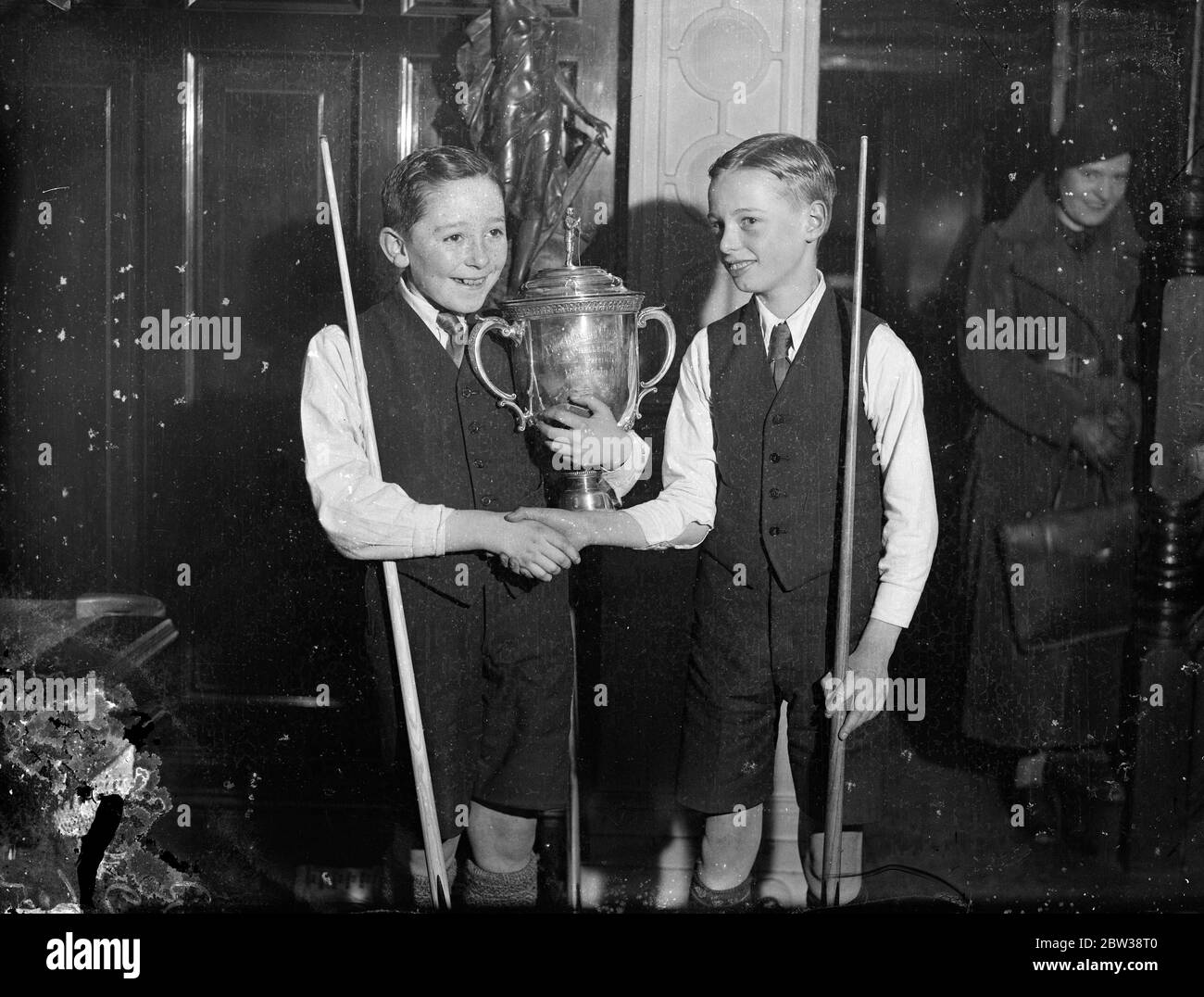 Finale del campionato del biliardo per ragazzi a Londra . Donald Cruickshank e Willie Swinhoe si sono incontrati nelle finali del Boys' Billiards Championship giocato a Burwatt Hall , Londra . Foto spettacoli ; Willie Swinhoe (a sinistra) , il vincitore con il trofeo che scuote le mani con il suo avversario perdente , Donald Cruickshank . 5 gennaio 1934 30s, 30s, 30s, 30s, 30s, 30ties, trents, 19theed trents Foto Stock