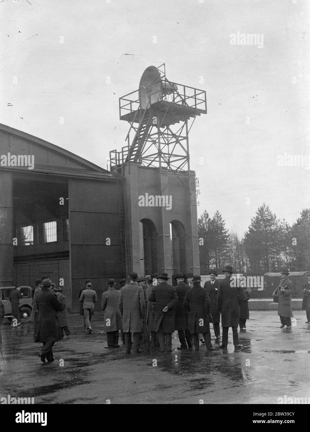 Sir Philip Sassoon inaugura la radio nana per volare più sicuro a Lympne . Sir Philip Sassoon , sotto il Segretario di Stato per l'aria , accompagnato dal colonnello Shelmerdine , Direttore dell'Aviazione civile e rappresentanti dei governi stranieri , ha ufficialmente inaugurato una stazione senza fili che lavora sulla lunghezza d'onda più corta mai utilizzata commercialmente all'Aerodromo di Lympne , Kent . La stazione opererà su una lunghezza d'onda di 8 pollici e sarà utilizzata come un collegamento radio ad alta efficienza attraverso il canale per aiutare i servizi aerei continentali . Un'altra stazione è stata costruita a St Inglevert , Francia per connettersi Foto Stock