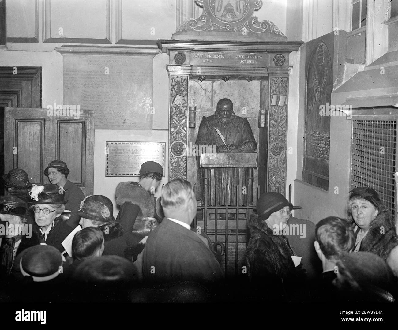 Servizio commemorativo per John Stow alla Chiesa dell'albero sotterraneo di St Andrew , Leadenhall Street , Londra . Il sindaco di Londra , Sir Charles Collett , ha partecipato ad un servizio commemorativo per John Stow , lo storico di Londra , che ha avuto luogo alla Chiesa Undershaft di St Andrew , Leadenhall Street , Londra . Il Sindaco del Signore ha messo una nuova penna di calle nella mano della statua di John Stow sulla sua tomba nella Chiesa . Foto spettacoli ; visitatori della chiesa guardando l'effigie di John Stow con la nuova penna di cigno in mano dopo il servizio . 27 aprile 1934 Foto Stock