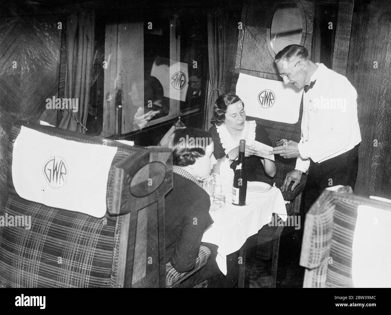 Ai passeggeri a bordo del Cornish Riviera Express viene offerto vino su un treno espresso che collega Londra e Penzance in Cornovaglia. 15 luglio 1935 Foto Stock